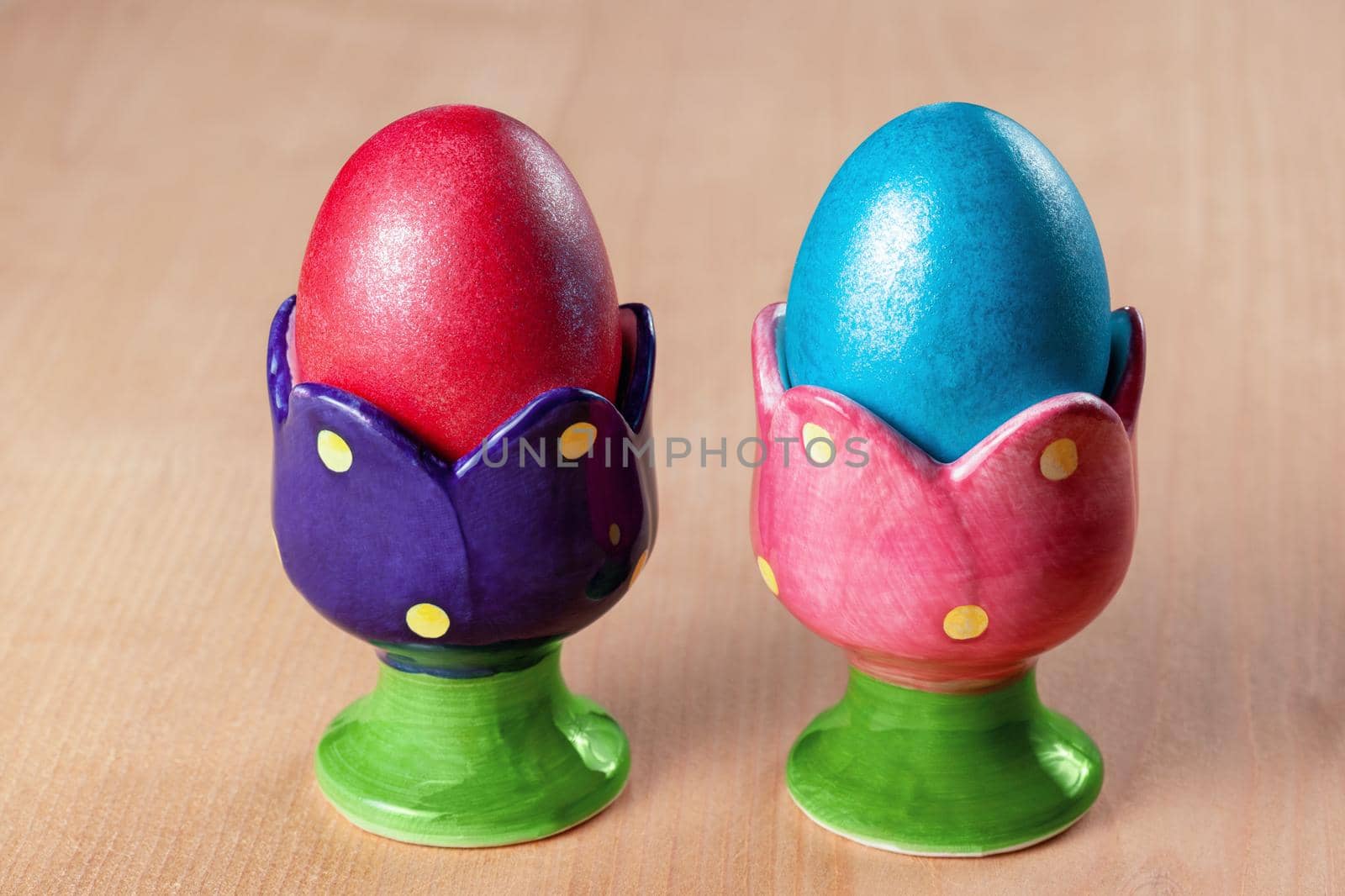 Colored easter eggs in egg cups by zhu_zhu