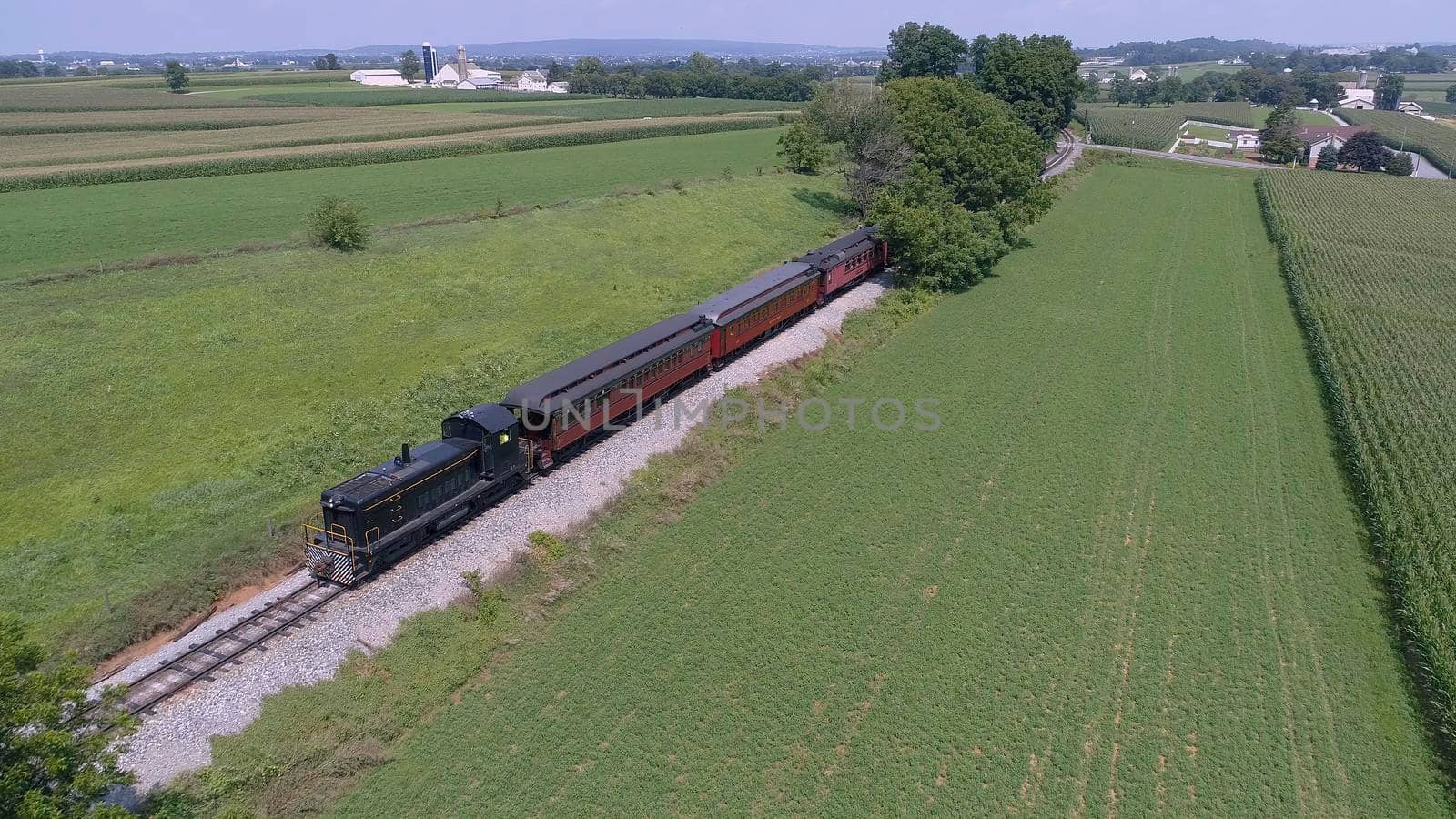 Aerial View of An Antique Restored Diesel Locomotive Traveling Thru Farmlands and Countryside on a Sunny Summer Day