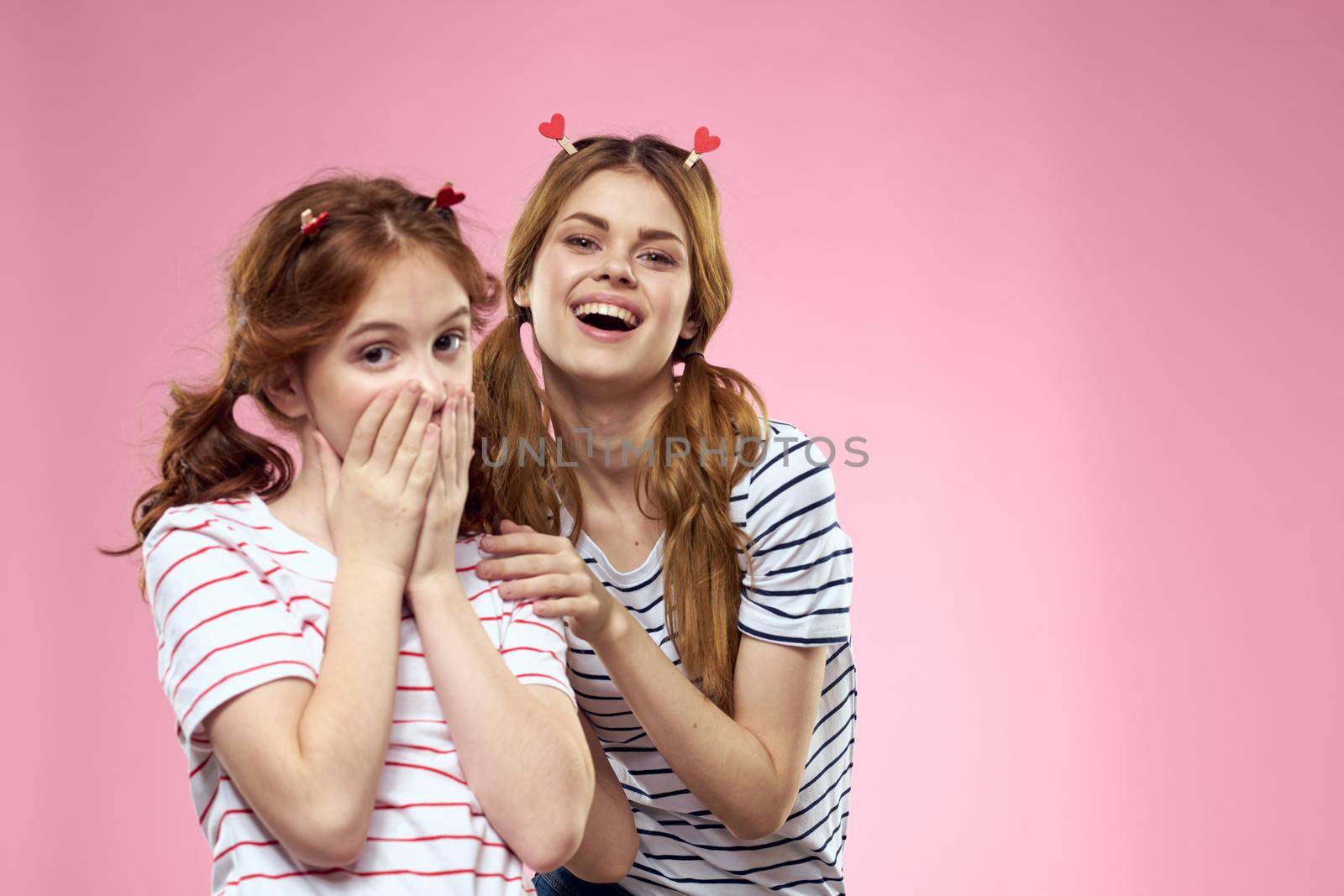 Woman and little girl on a pink background fun sisters friends family. High quality photo