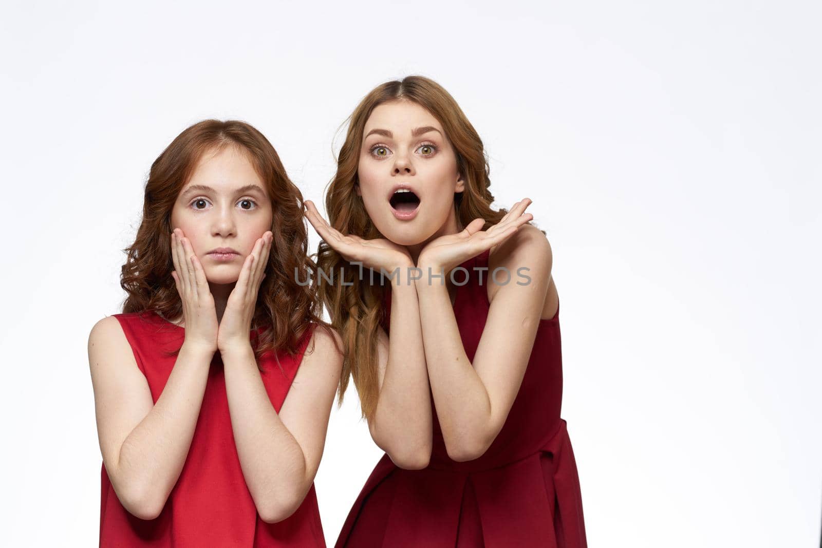 Cheerful mom and daughter next to red dresses hugs lifestyle light background smile by SHOTPRIME
