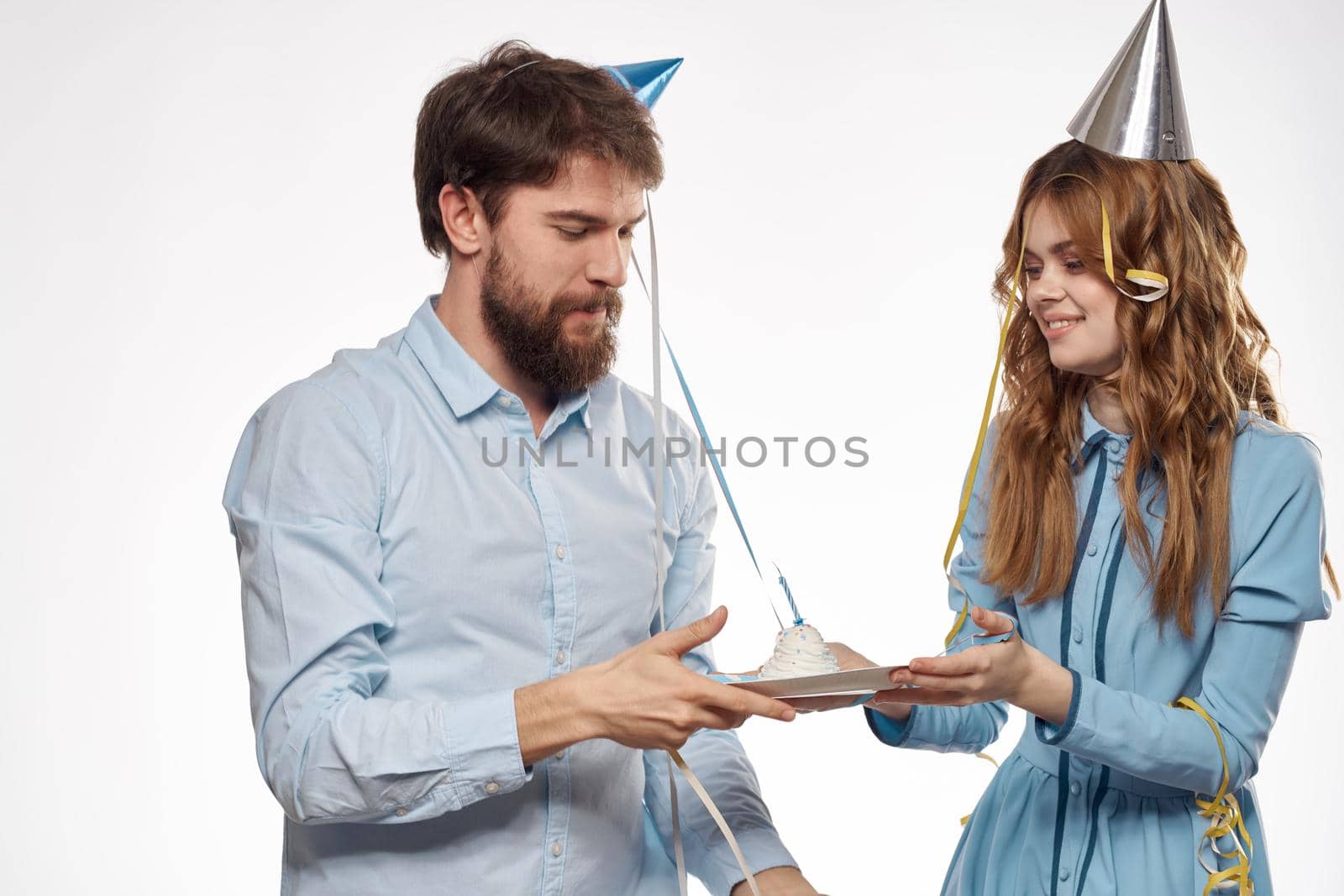 Joyful man and cheerful Woman holiday cake Birthday cap party corporate party young people. High quality photo