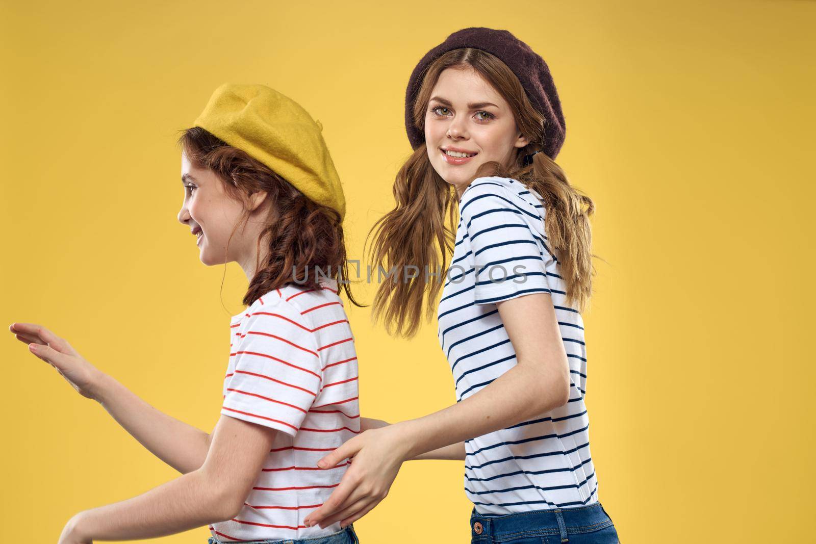 Mom and daughter embrace joy fun childhood lifestyle yellow background. High quality photo