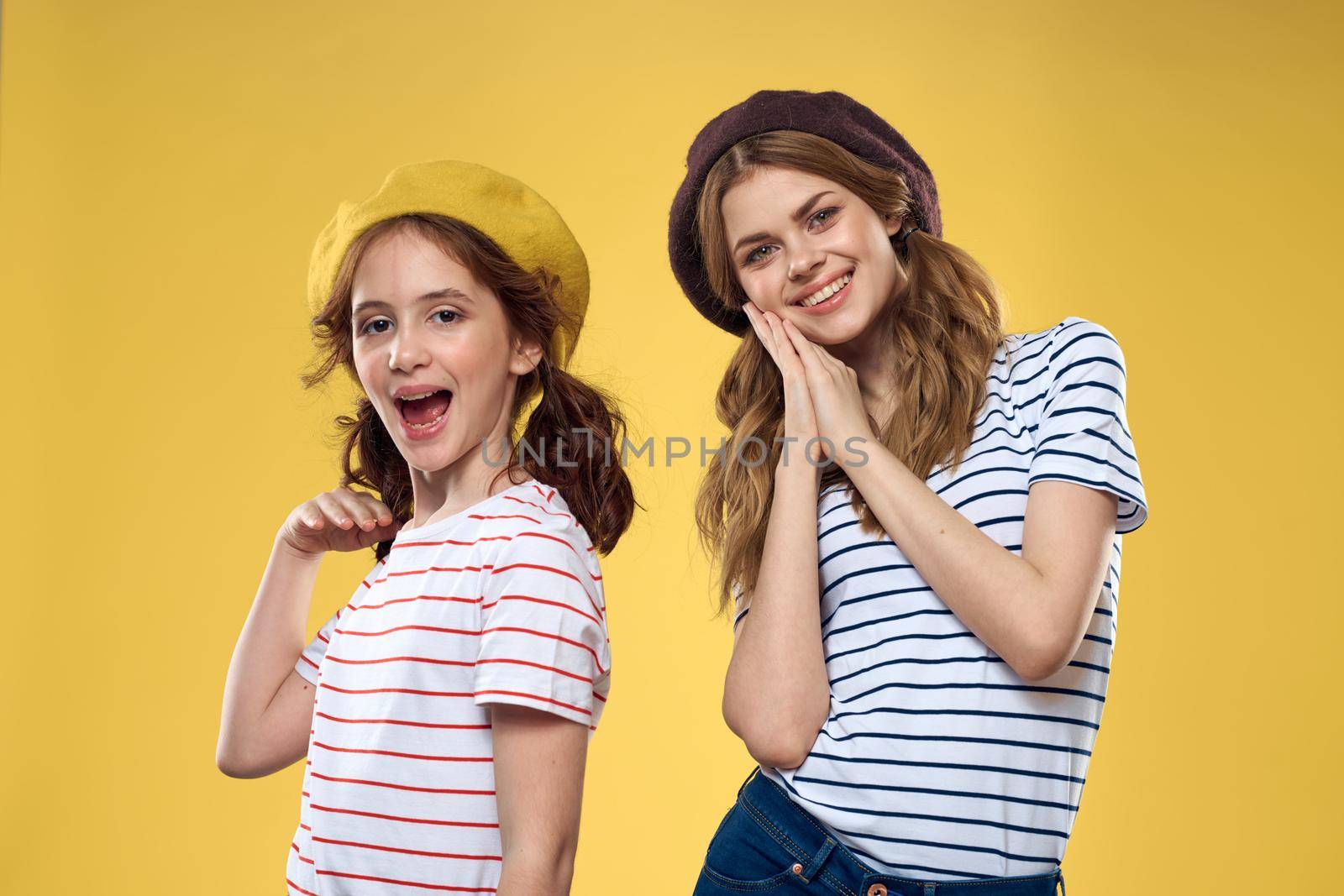 Mom and daughter embrace joy fun childhood lifestyle yellow background. High quality photo