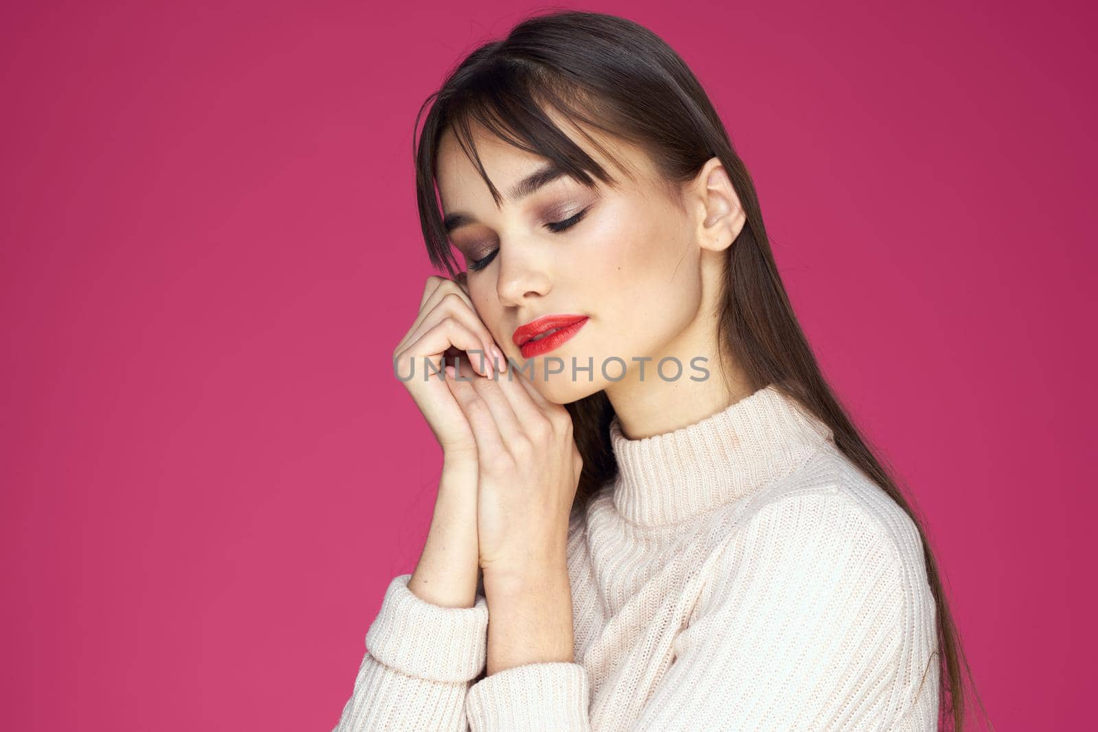Woman with red lips bright makeup white blouse long hair pink background. High quality photo