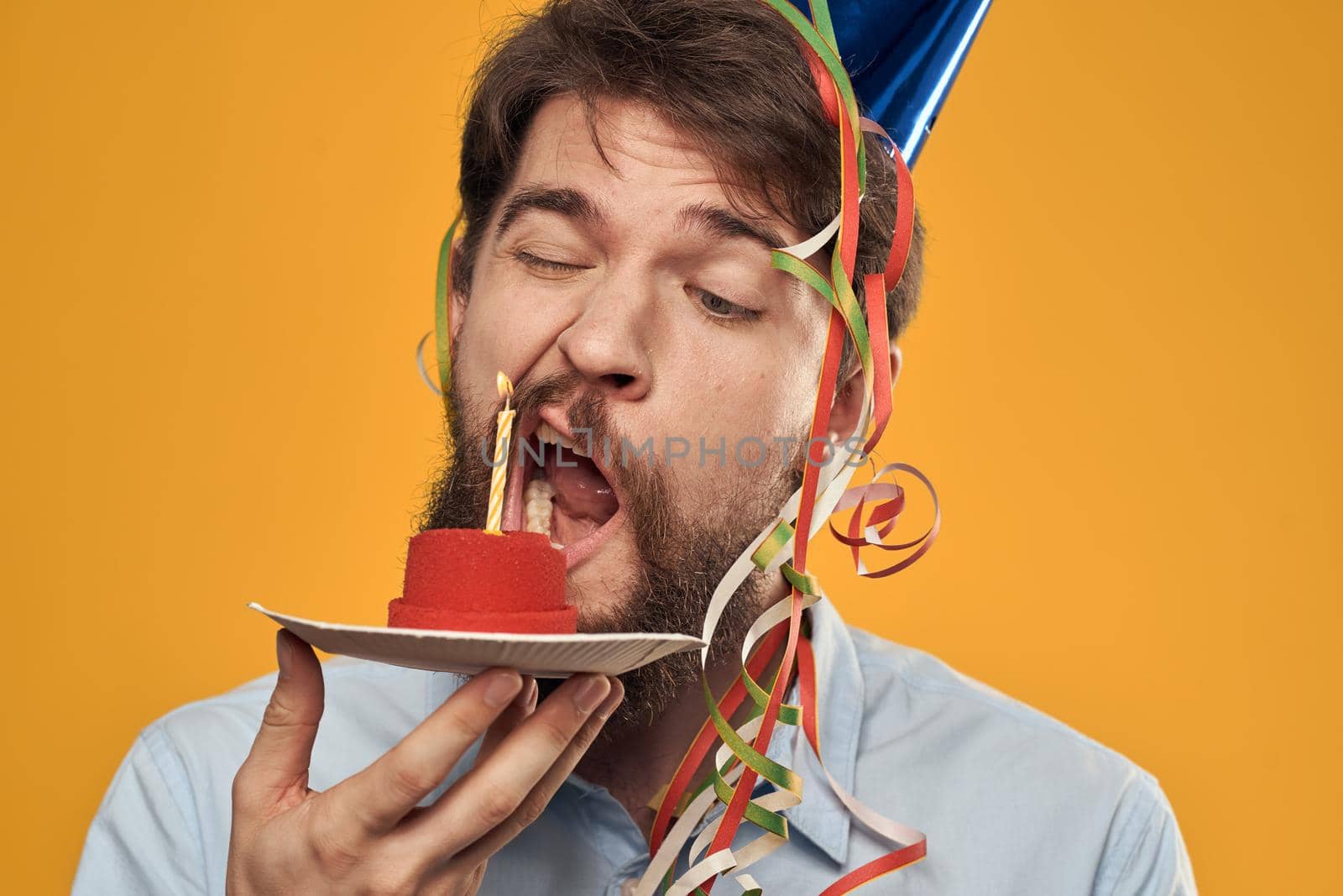 Birthday boy in a cap with a birthday cake in his hand and a candle. High quality photo