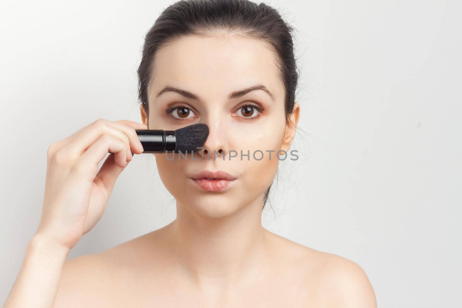 brunette bare shoulders face cream skin care cosmetics. High quality photo