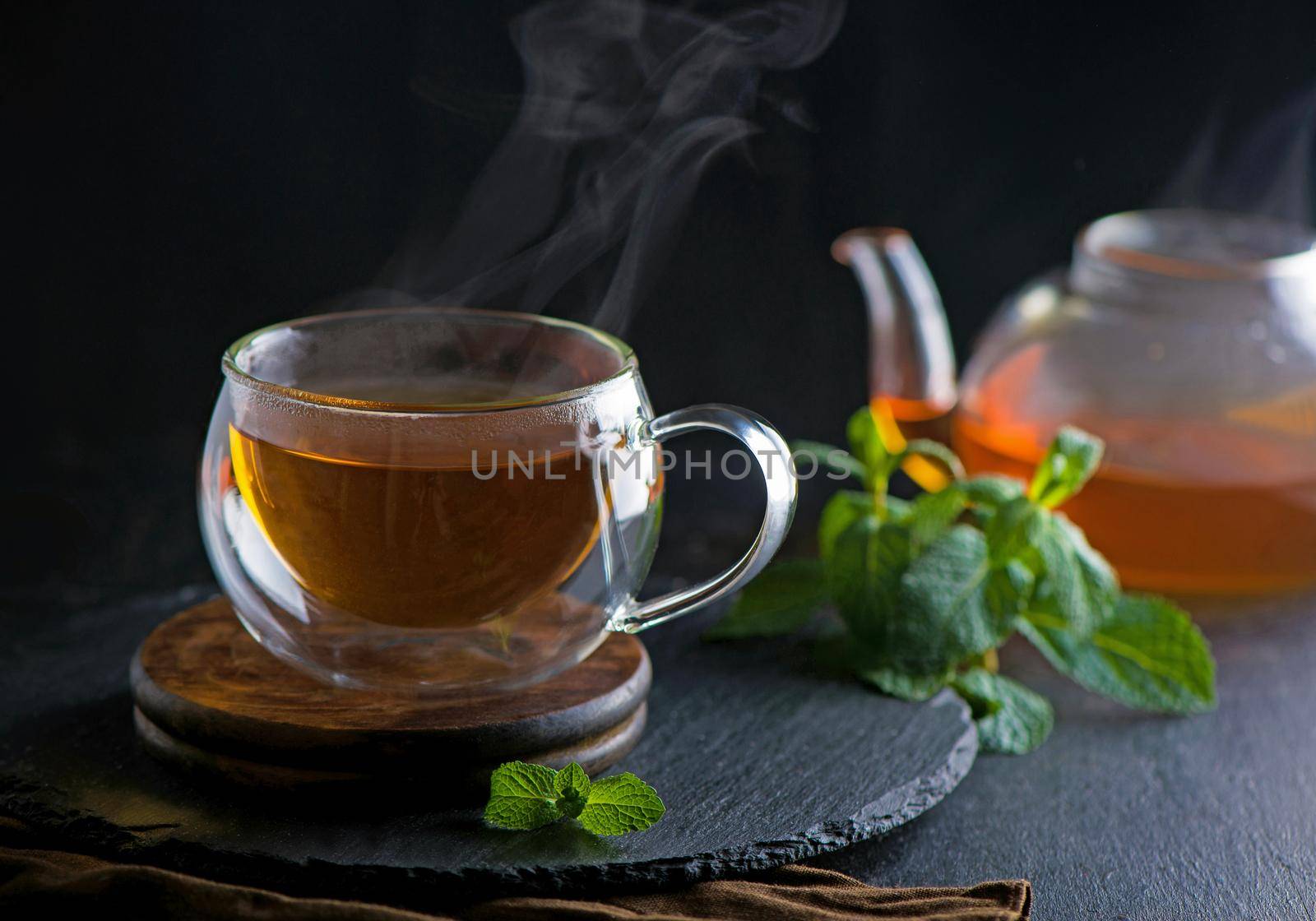 Tea concept, teapot with tea surrounded on wood background, tea ceremony, green tea in a transparent cup by aprilphoto