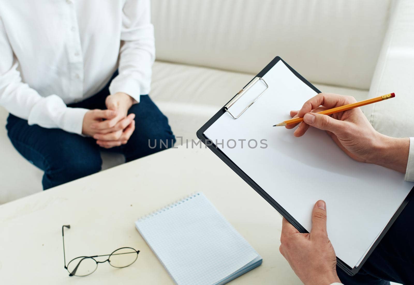 White sheet of paper a man writes information and a woman at a table indoors. High quality photo