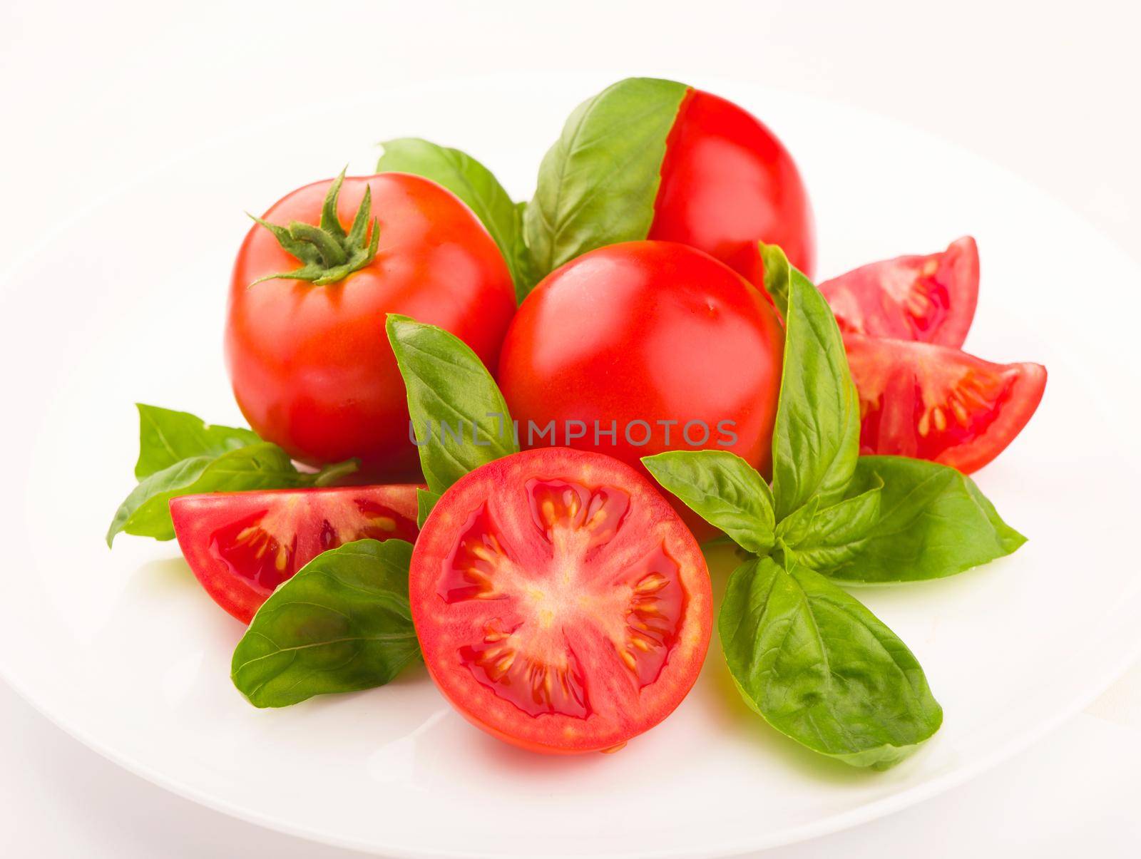 Tomatoes and basil leaves isolated on white close up. Vegetables by aprilphoto