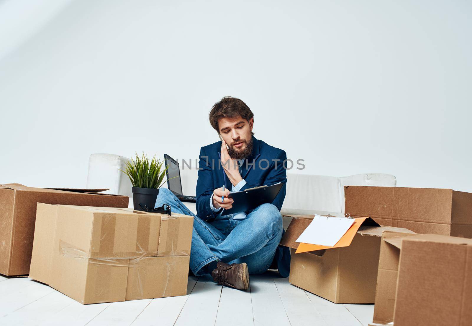 A man in a suit boxes with things communicating on the phone office official unpacking. High quality photo