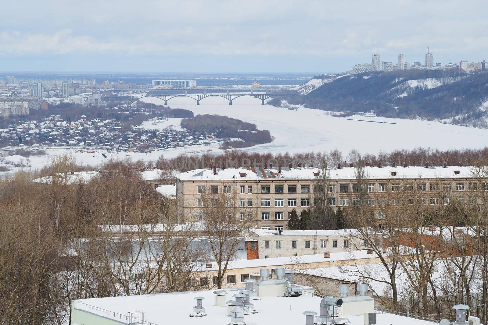 Panoramic view from above of a large industrial city by the river in winter. High quality photo