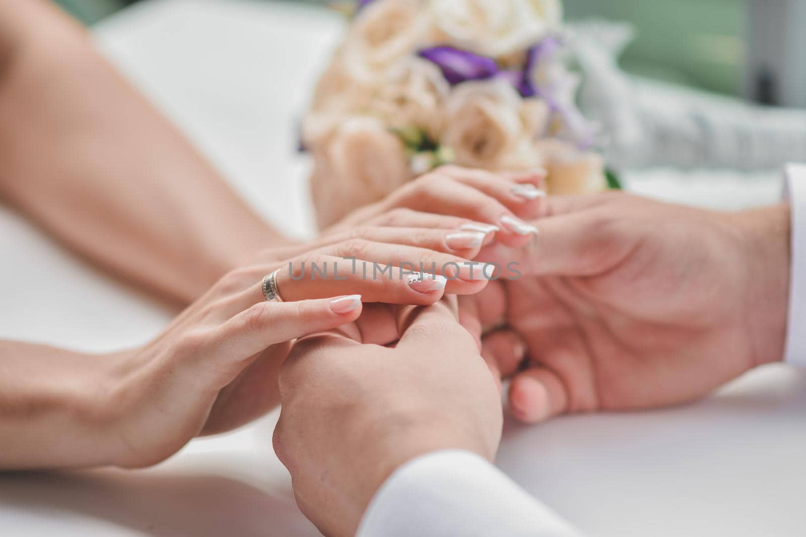 A guy holds his girlfriend's hands. The man gave the woman a bouquet of flowers. Feelings of love. Selective defocusing. Without face