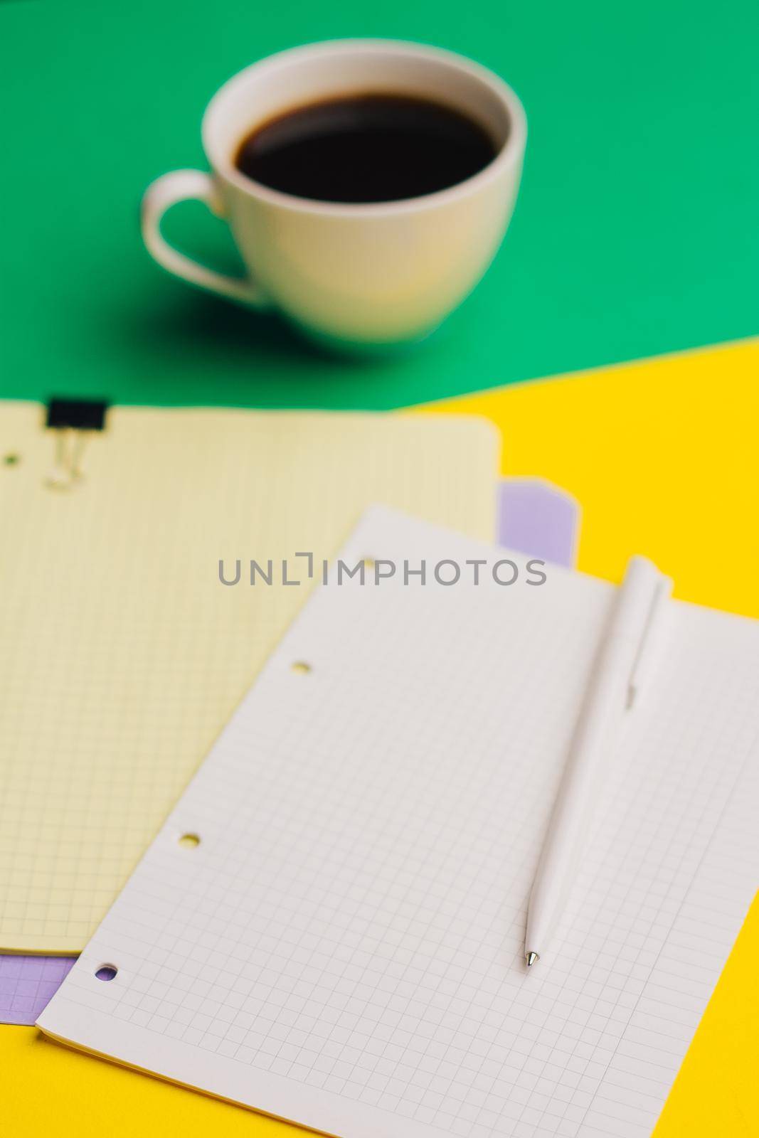 cup of coffee on a colored background and sheets of paper notepad office glasses. High quality photo