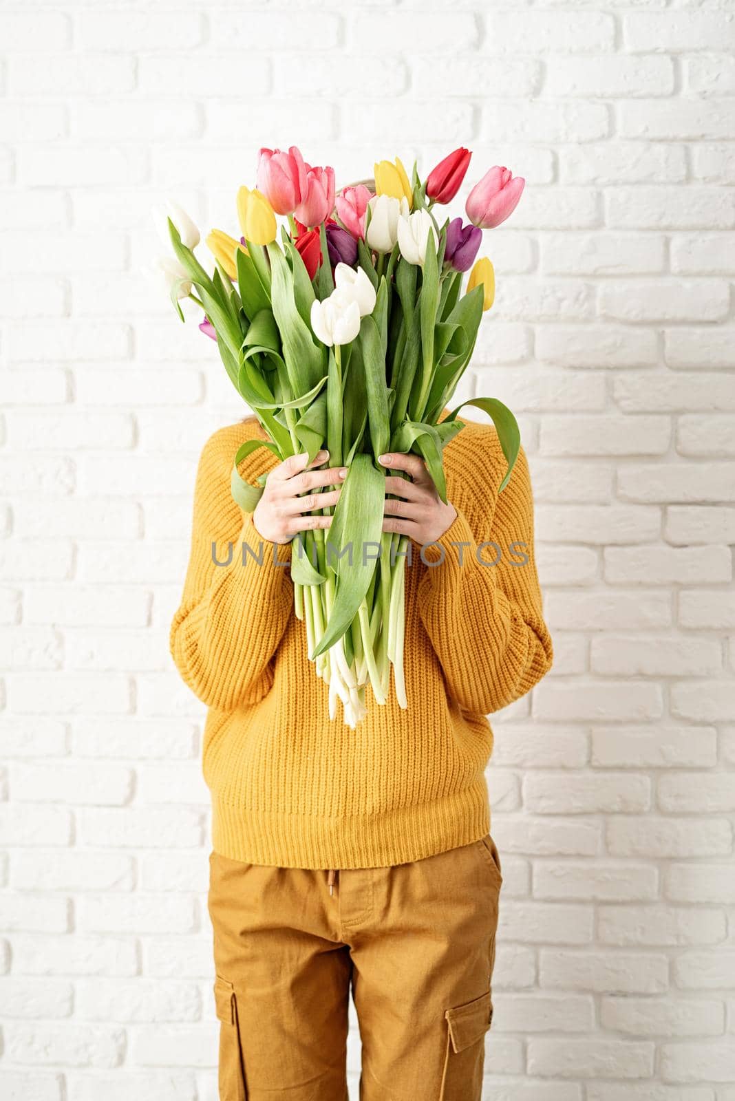 Mothers Day, Women's Day concept. Spring holidays. Happy young woman holding bouquet of tulips