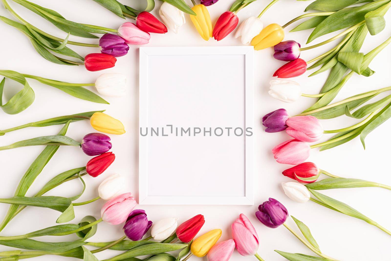 Frame mock up with beautiful colorful tulips on white background. Flat lay, top view.