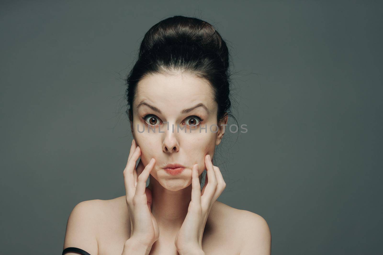 pretty woman grimacing on gray background cropped view portrait emotion. High quality photo