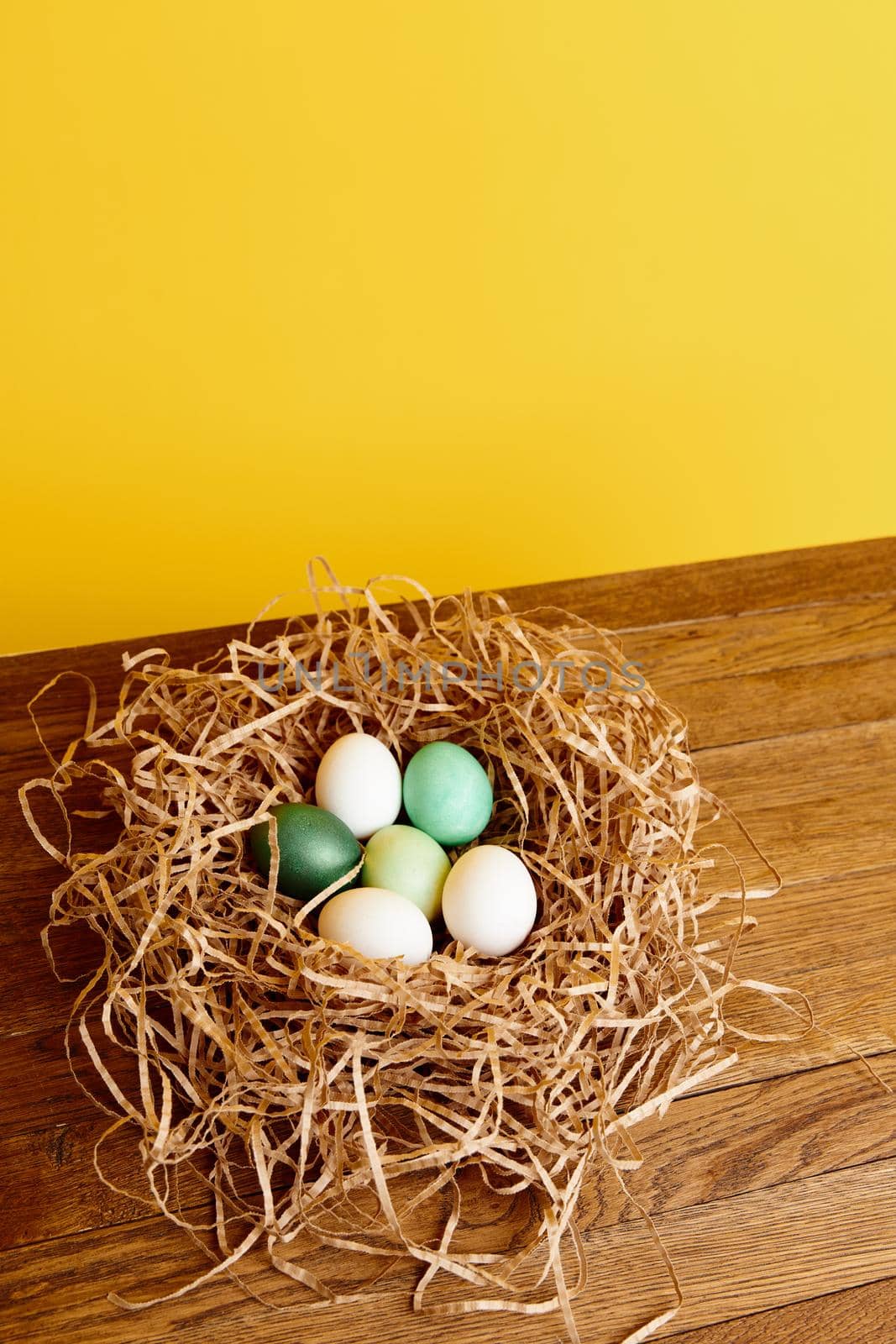 Easter eggs decorated in a nest on a yellow background holiday. High quality photo