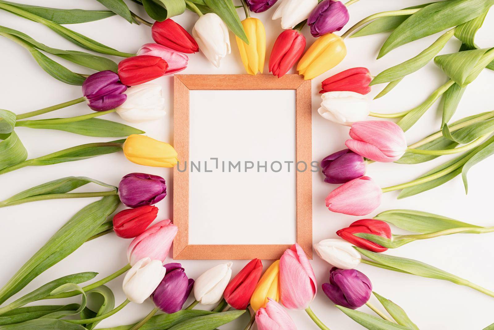 Frame mock up with beautiful colorful tulips on white background. Flat lay, top view.