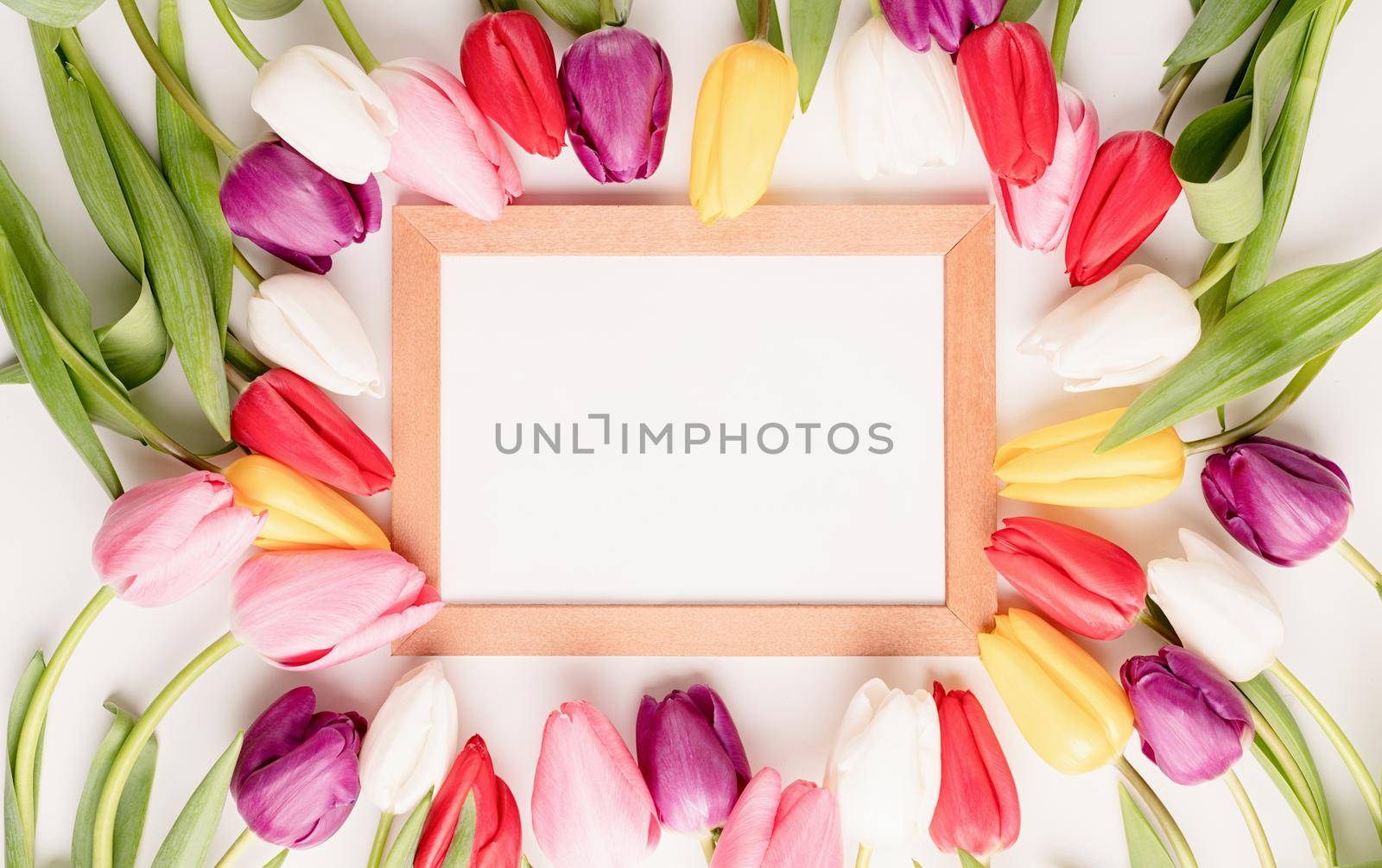 Frame mock up with beautiful colorful tulips on white background. Flat lay, top view.