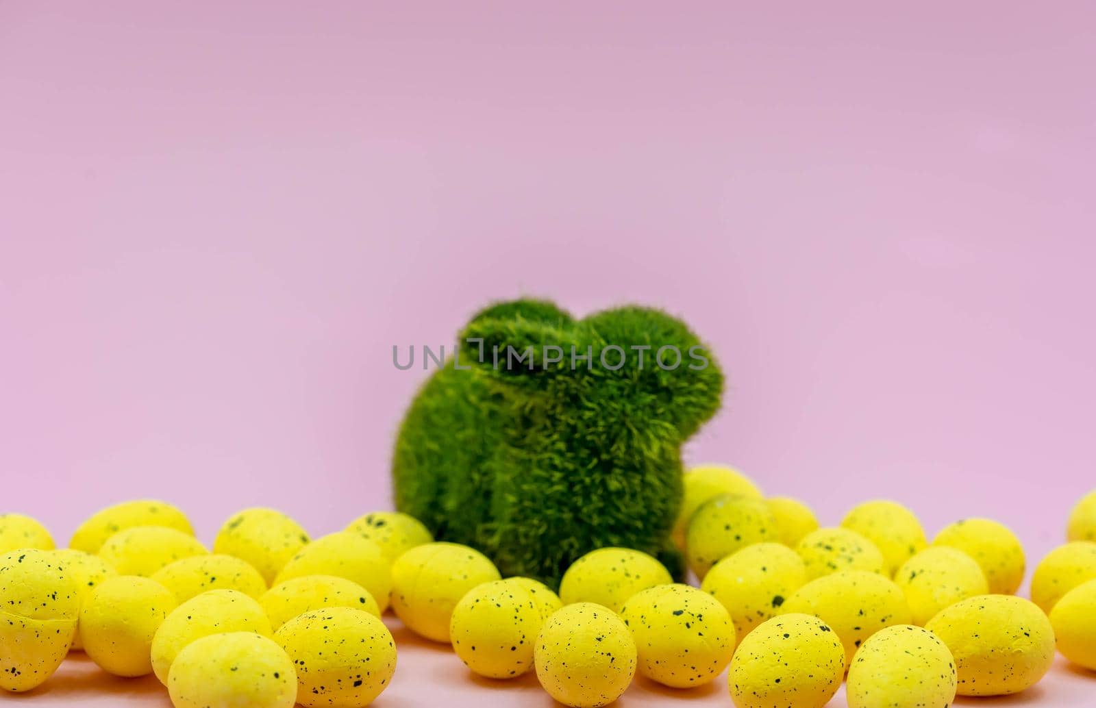 Yellow Easter Egg with freckles pattern and Rabbit Bunny on Pink Background