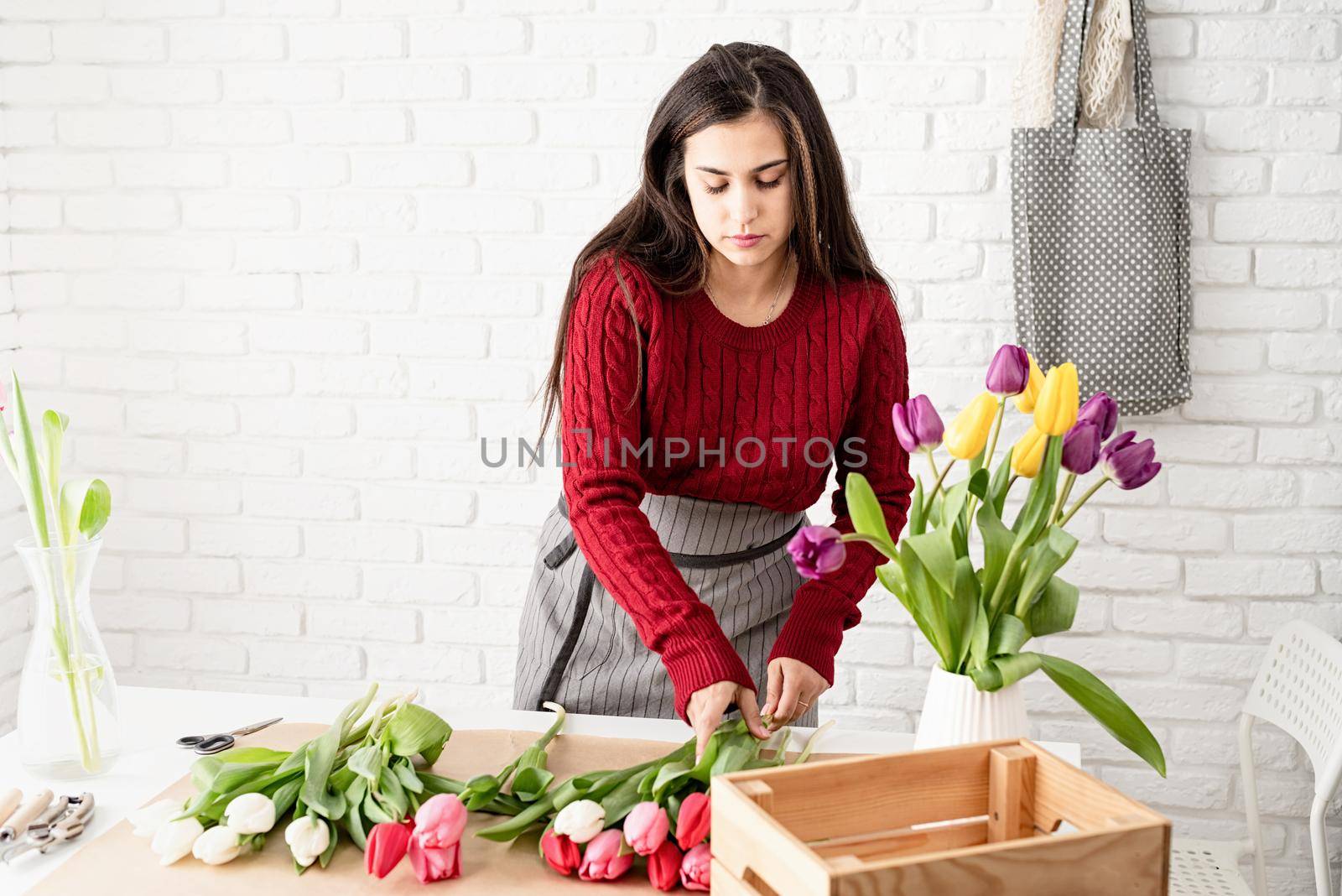 Valentine's Day and Women's Day. Small business. Woman florist making a bouquet of fresh colorful tulips