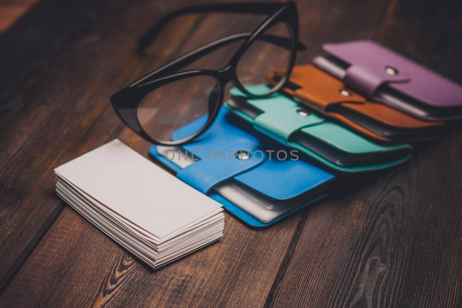 business card holders and a pack of white paper on a wooden background glasses with black frames. High quality photo