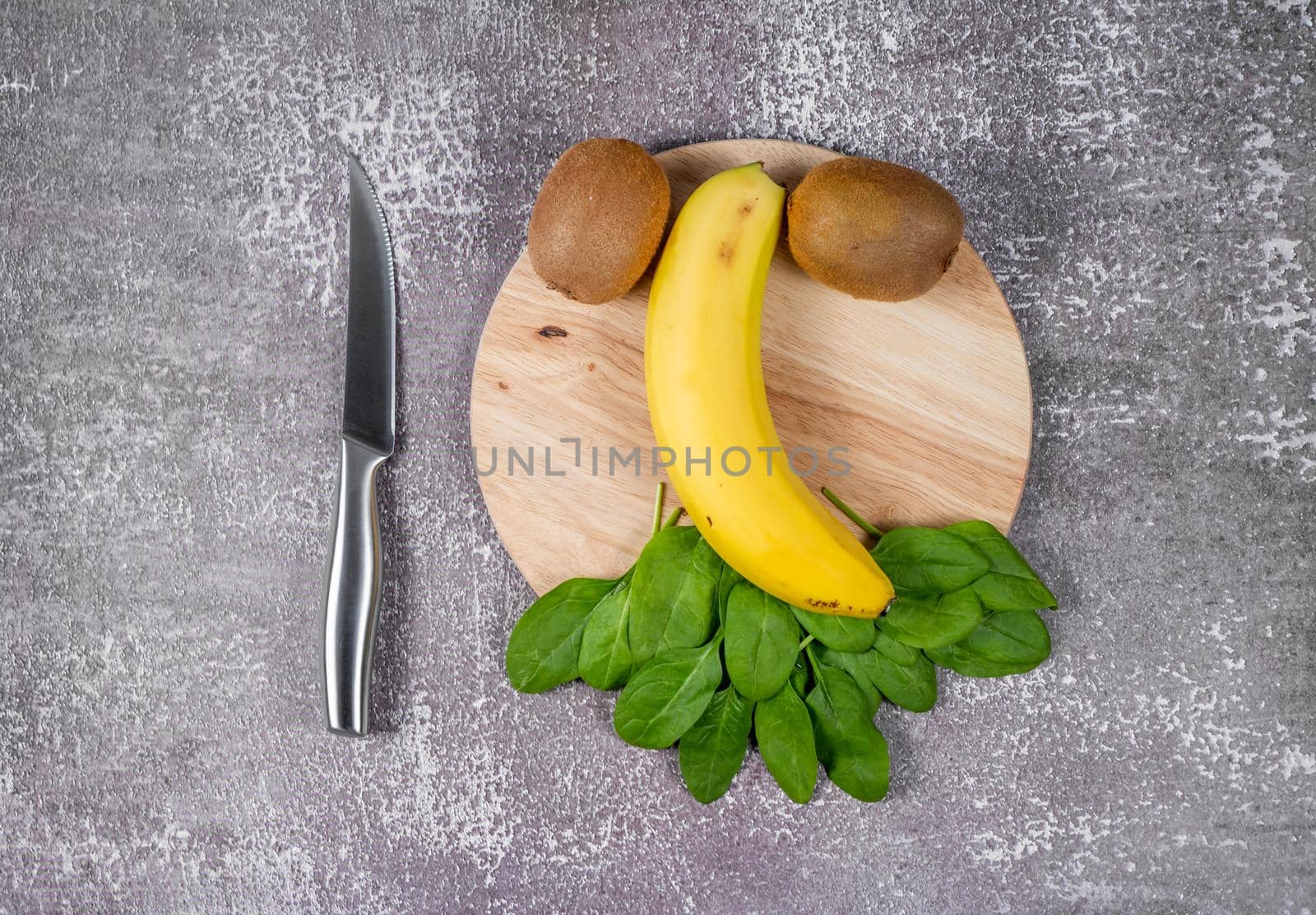 Step 1. Preparation of products for smoothies. Banana, kiwi and spinach on a cutting board.