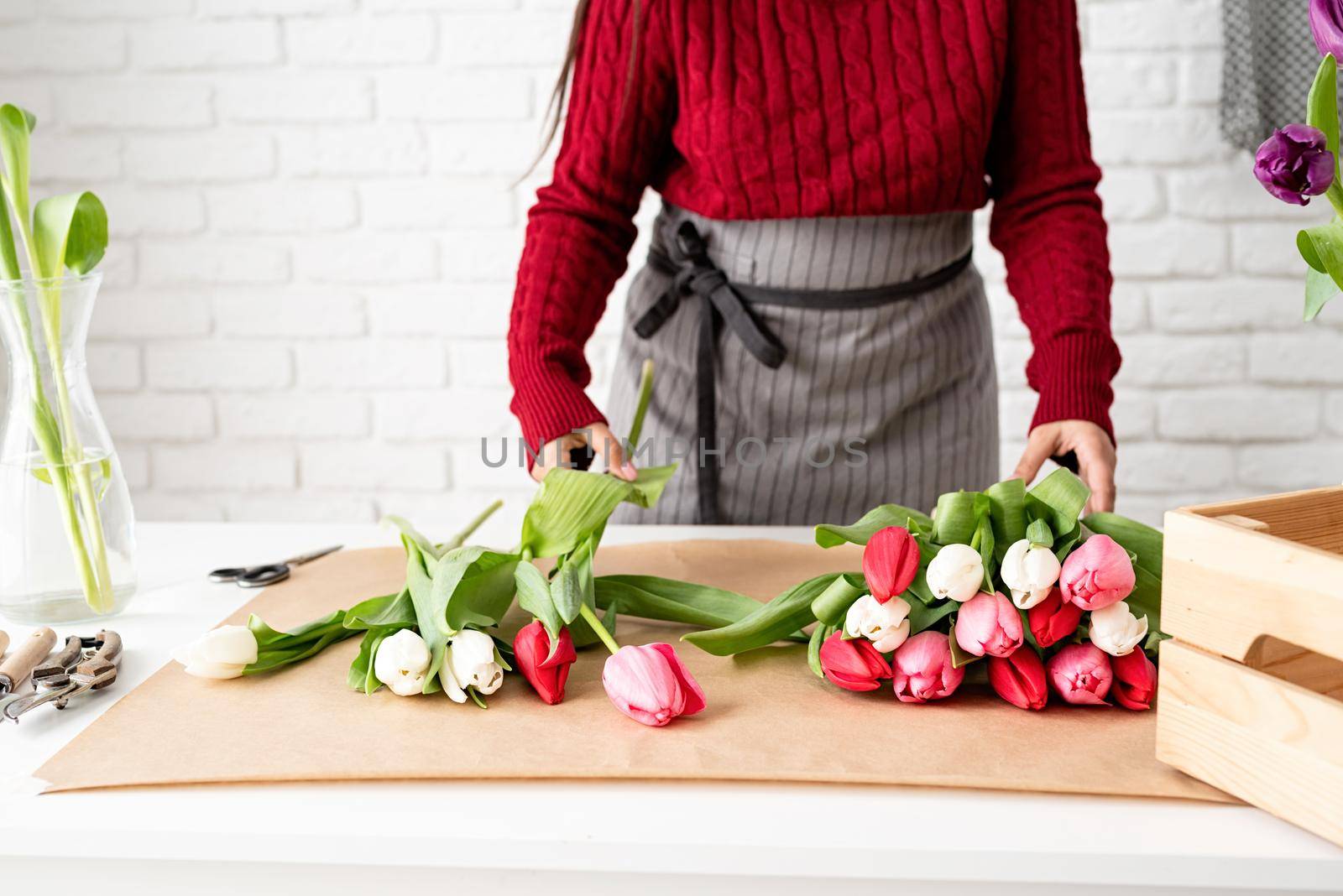 Valentine's Day and Women's Day. Small business. Woman florist making a bouquet of fresh colorful tulips