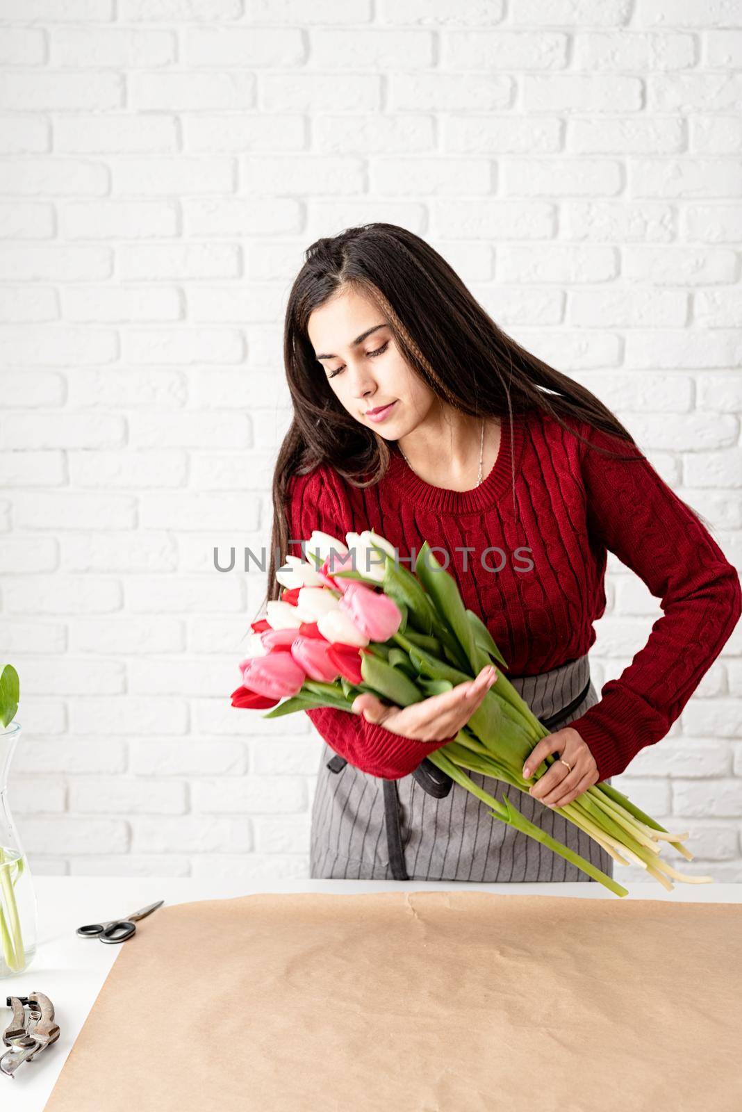 Valentine's Day and Women's Day. Small business. Woman florist making a bouquet of fresh colorful tulips