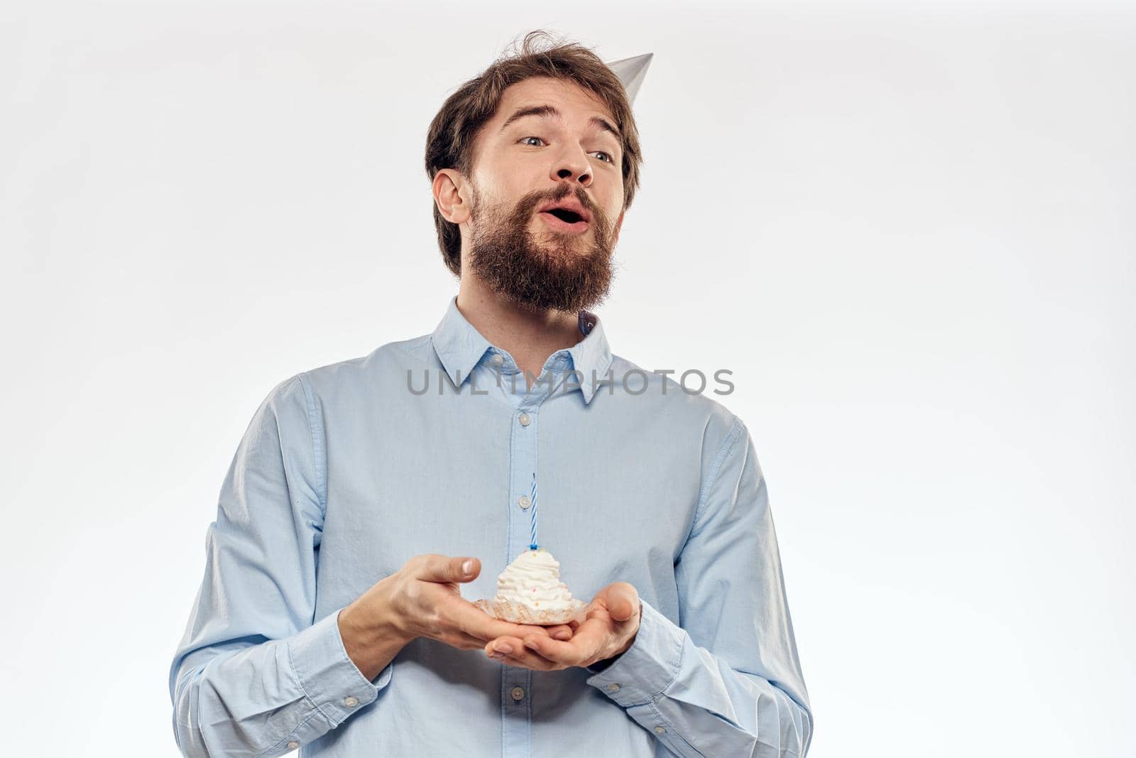 a man with a beard holds a cake in his hand on a light background birthday. High quality photo