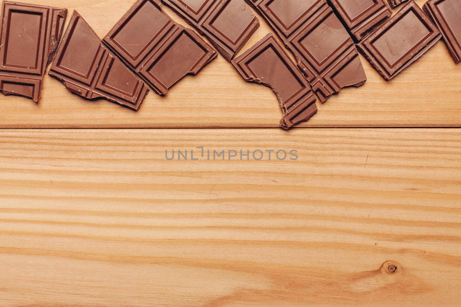 broken brown chocolate bar and background image texture top view. High quality photo