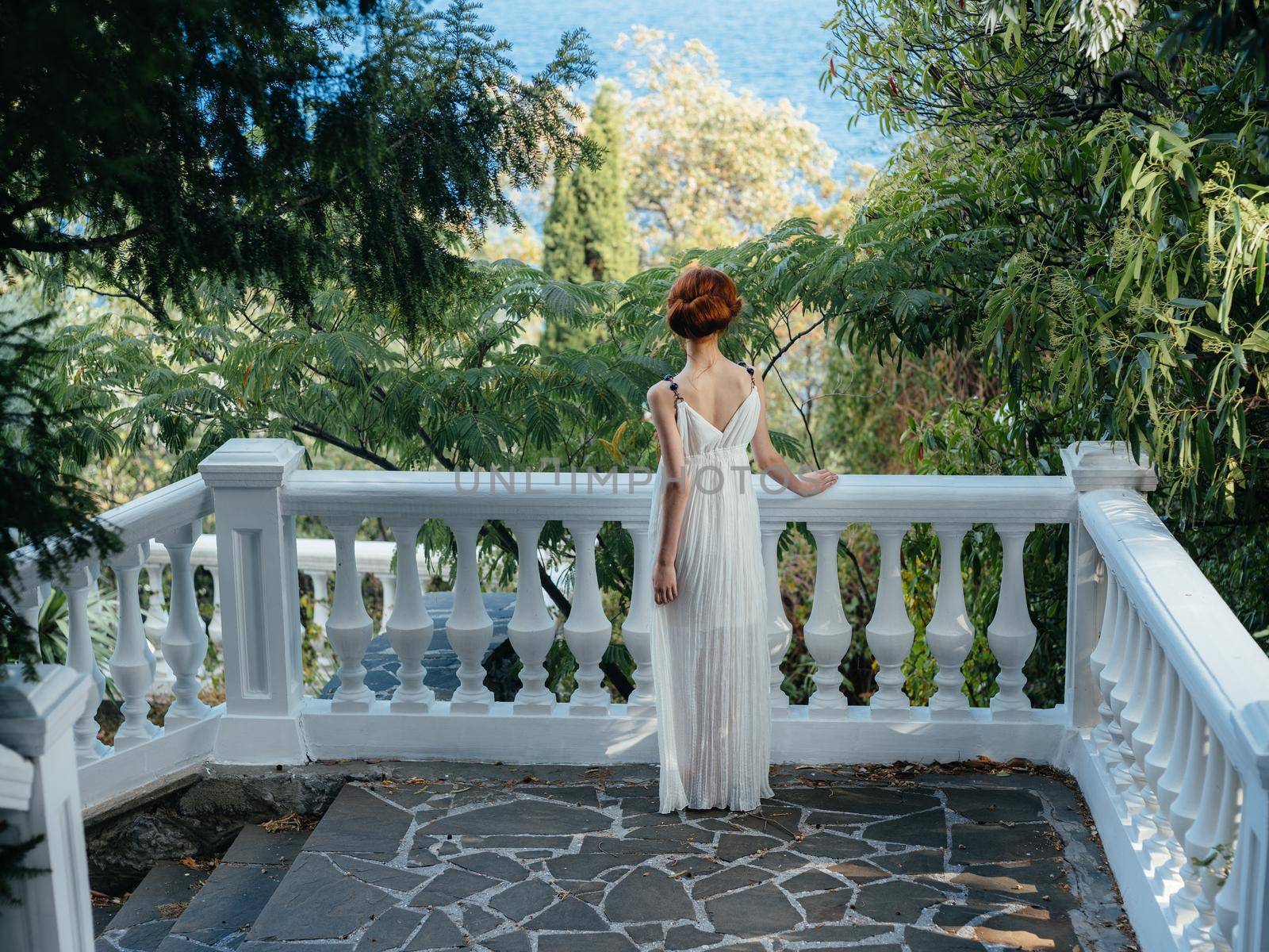 Beautiful woman white dress glamor green leaves summer Greece by SHOTPRIME