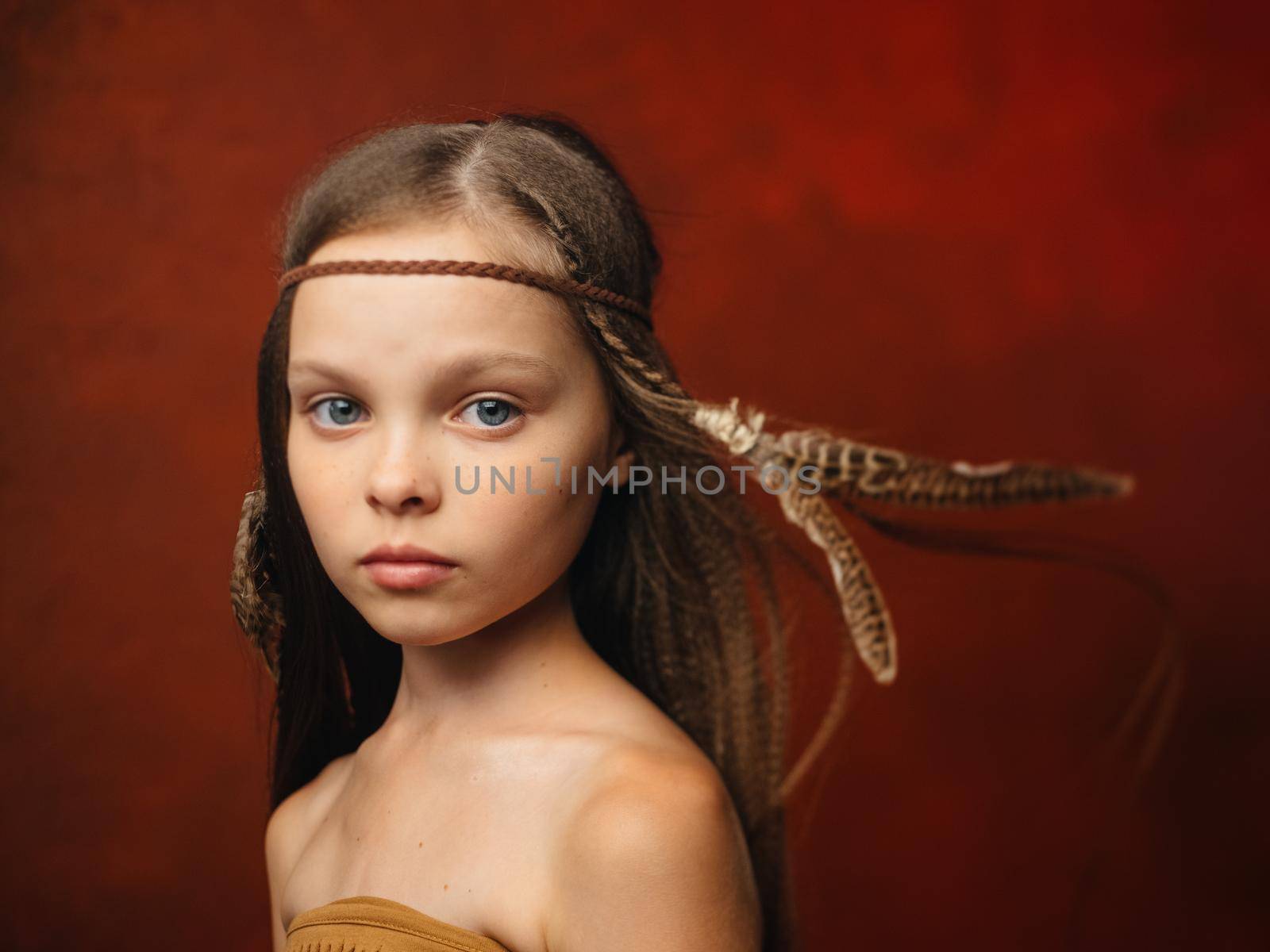 girl with a feather in her hair savage aboriginal shaman indian tribe. High quality photo