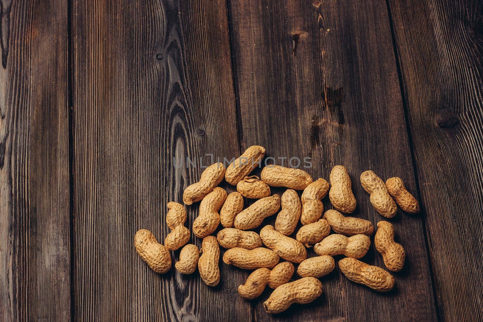 scattered peanuts in shells on a wooden table top view beer snack. High quality photo