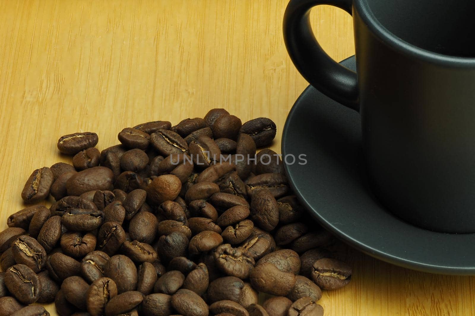 The background is made of natural coffee beans and a coffee cup in the background. It's a macro-