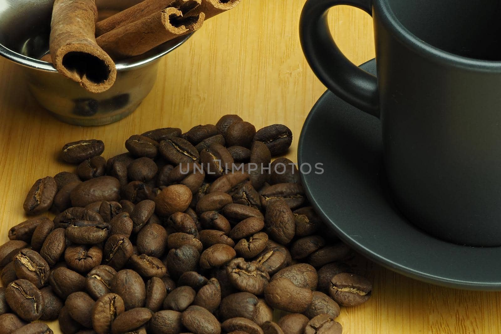 Coffee beans with a cup of coffee and a cinnamon stick a beautiful background. by Olga26