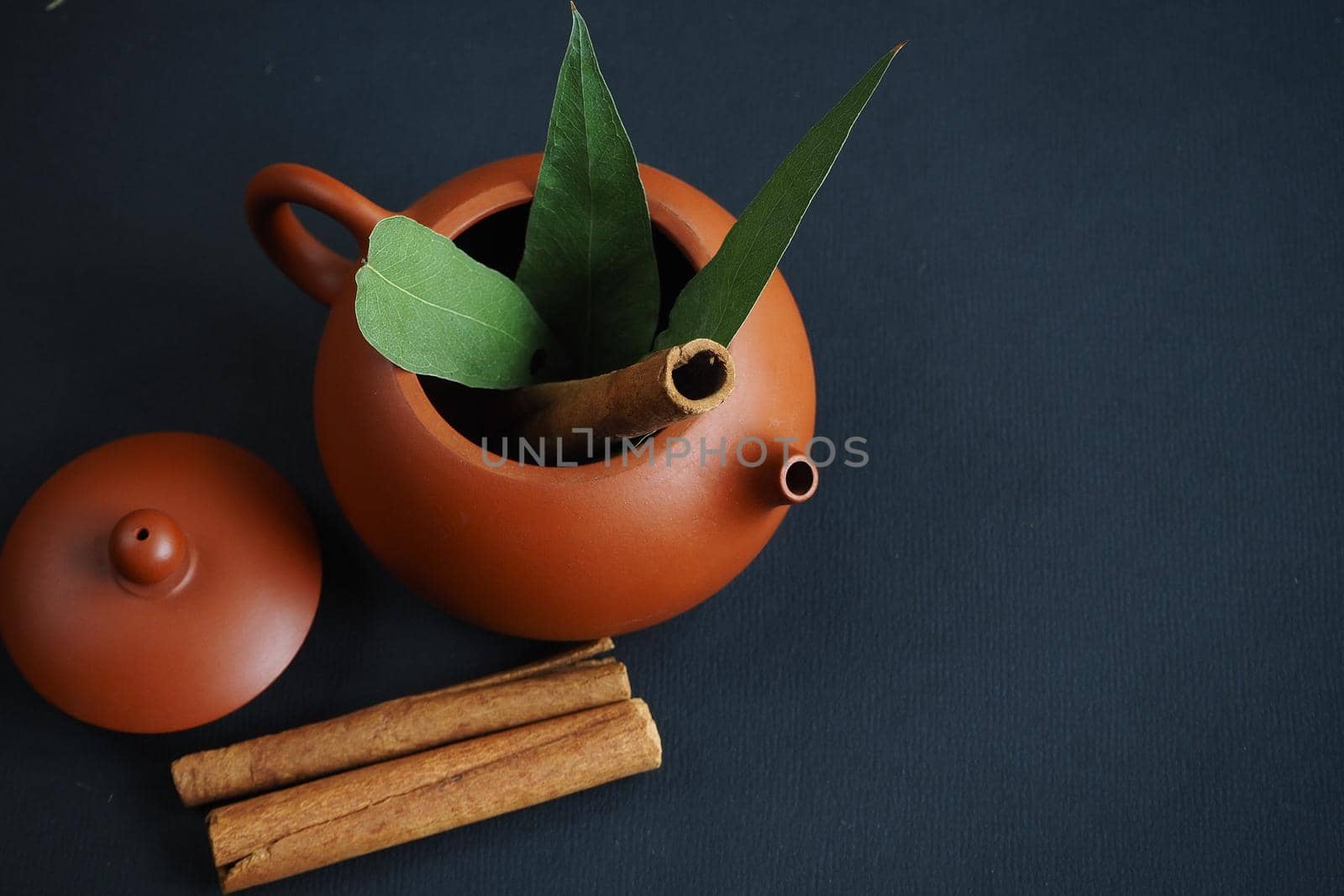 Clay Chinese teapot with cinnamon and eucalyptus leaves