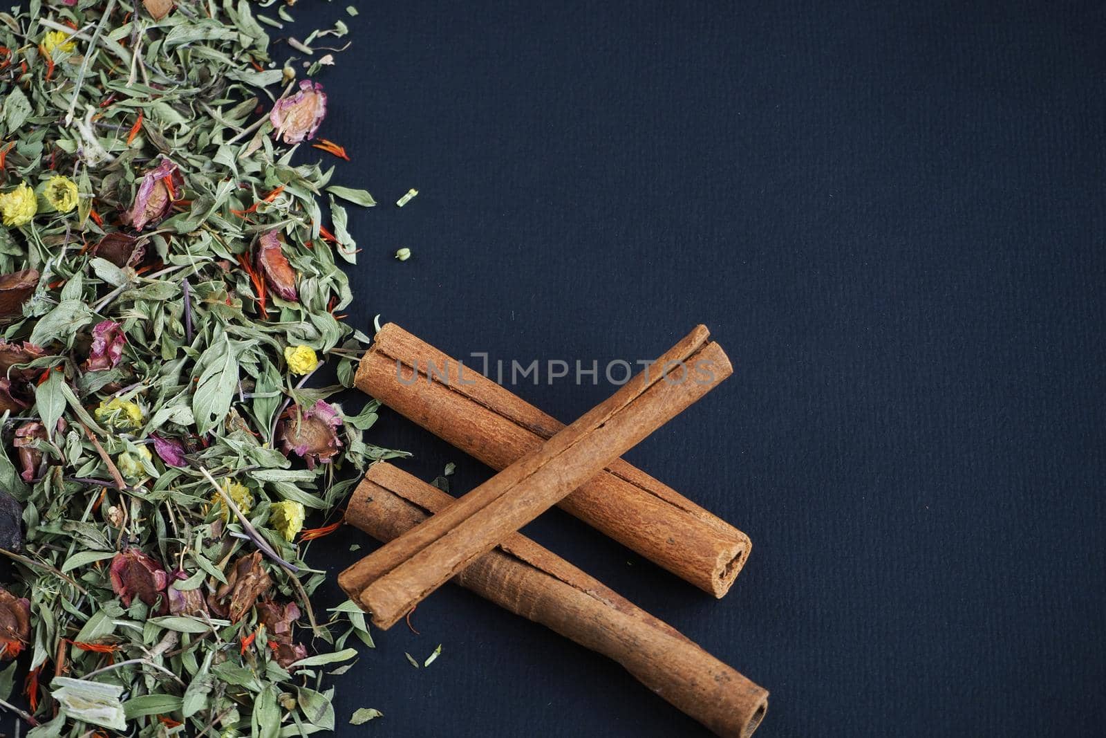 Dried cinnamon sticks and herbal tea on a black background. A quality image.