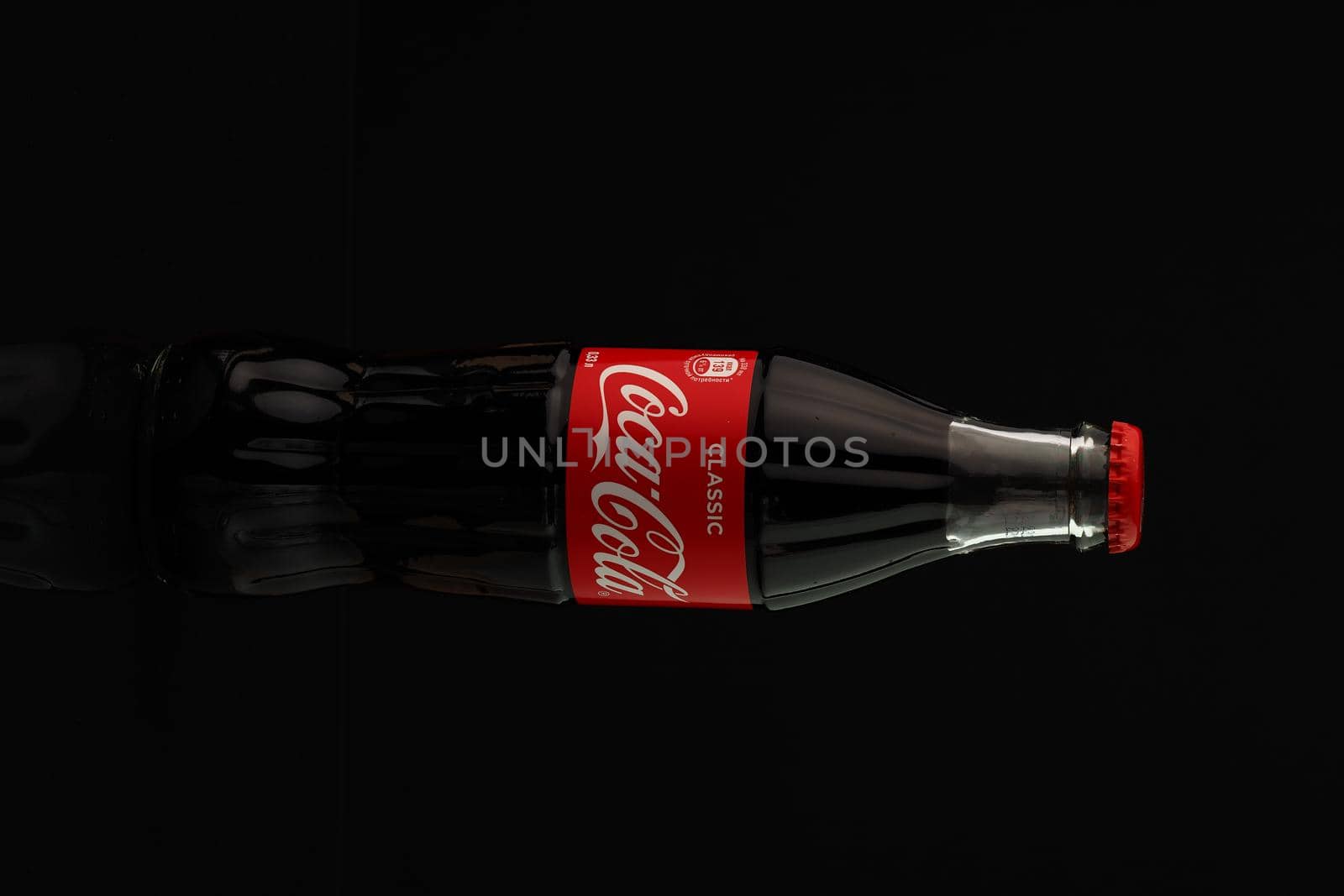 Coca-Cola. A classic glass transparent bottle of Coca-Cola with a red lid, insulated on a black background. High quality photo.Russia, Nizhny Novgorod, 19.02 2021. 