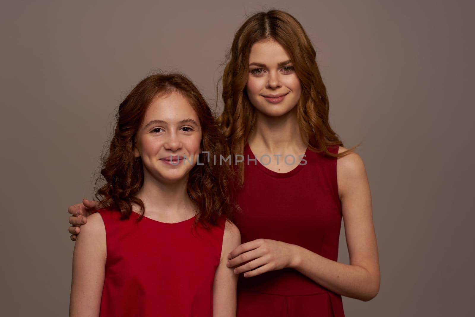 Cheerful mom and little daughter hug smile gray background. High quality photo