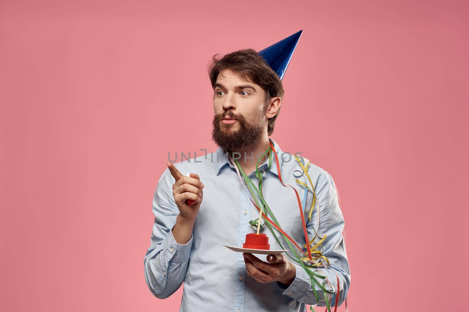 Happy car with a cake on a pink background and in a cap in Copy Space holidays birthday. High quality photo