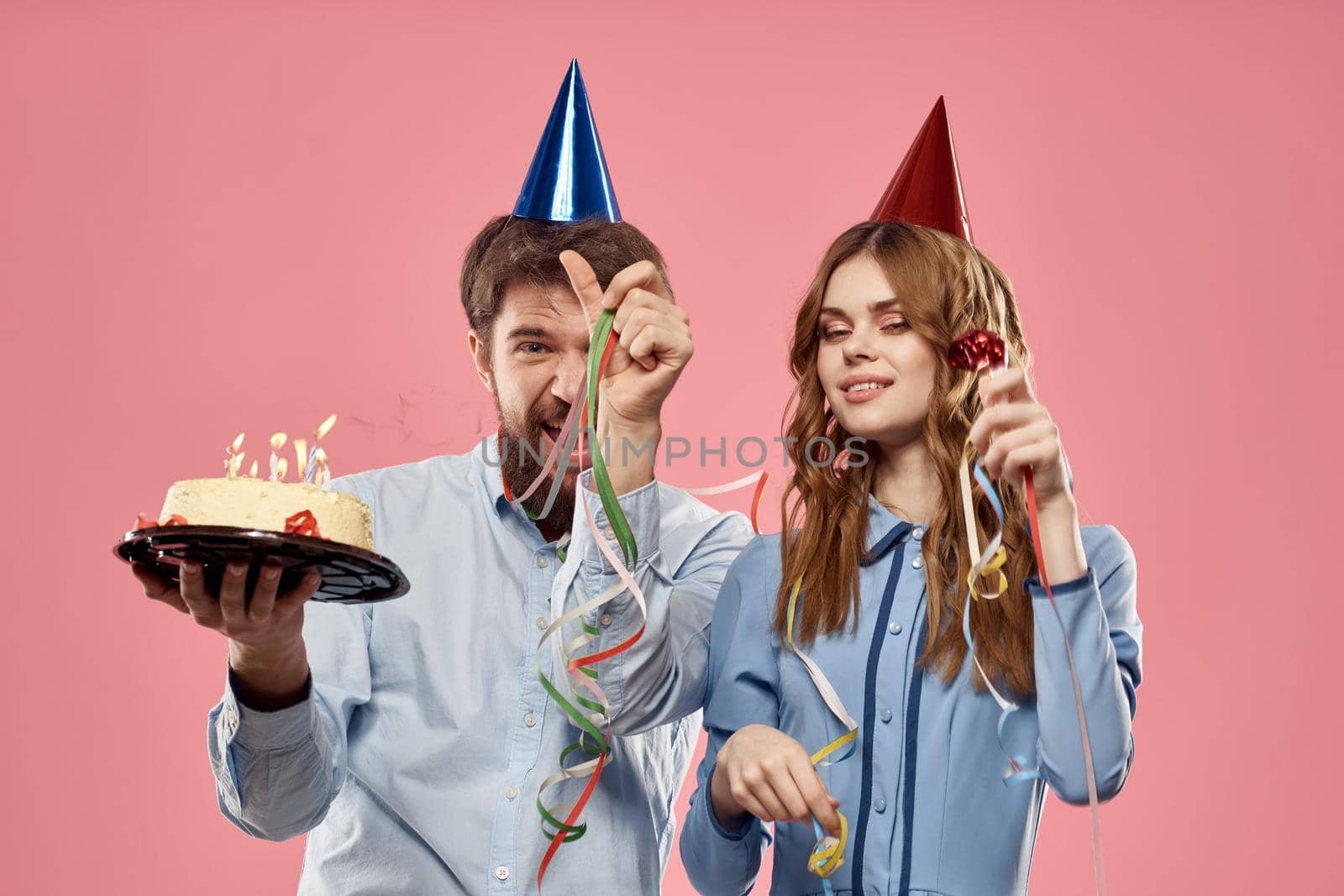 Party man and woman with cake on pink background corporate birthday. High quality photo