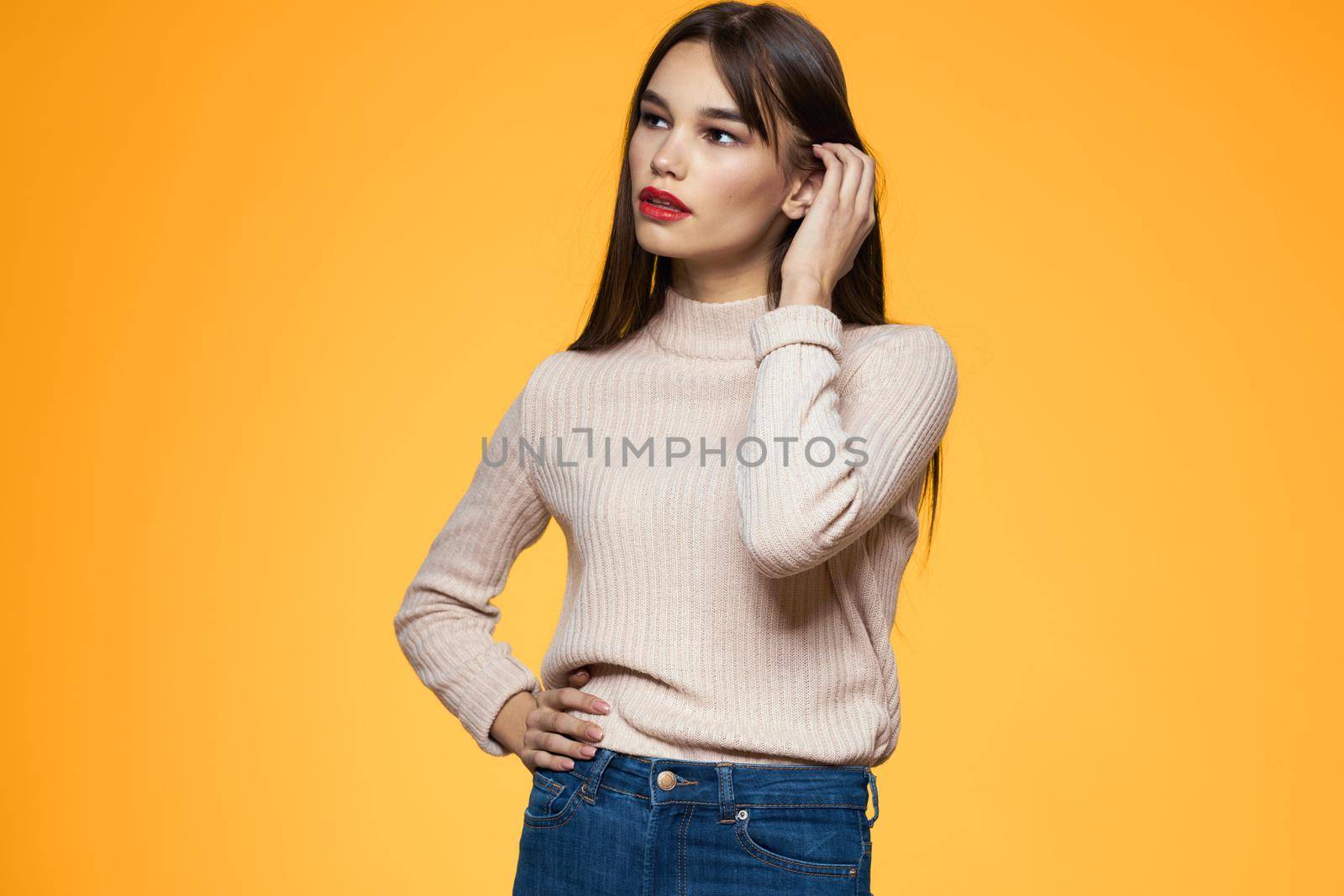 Cute brunette red lips fashionable clothes studio yellow background. High quality photo