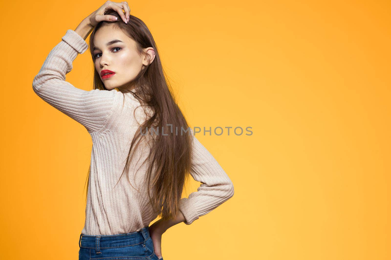 Cute brunette red lips fashionable clothes studio yellow background. High quality photo