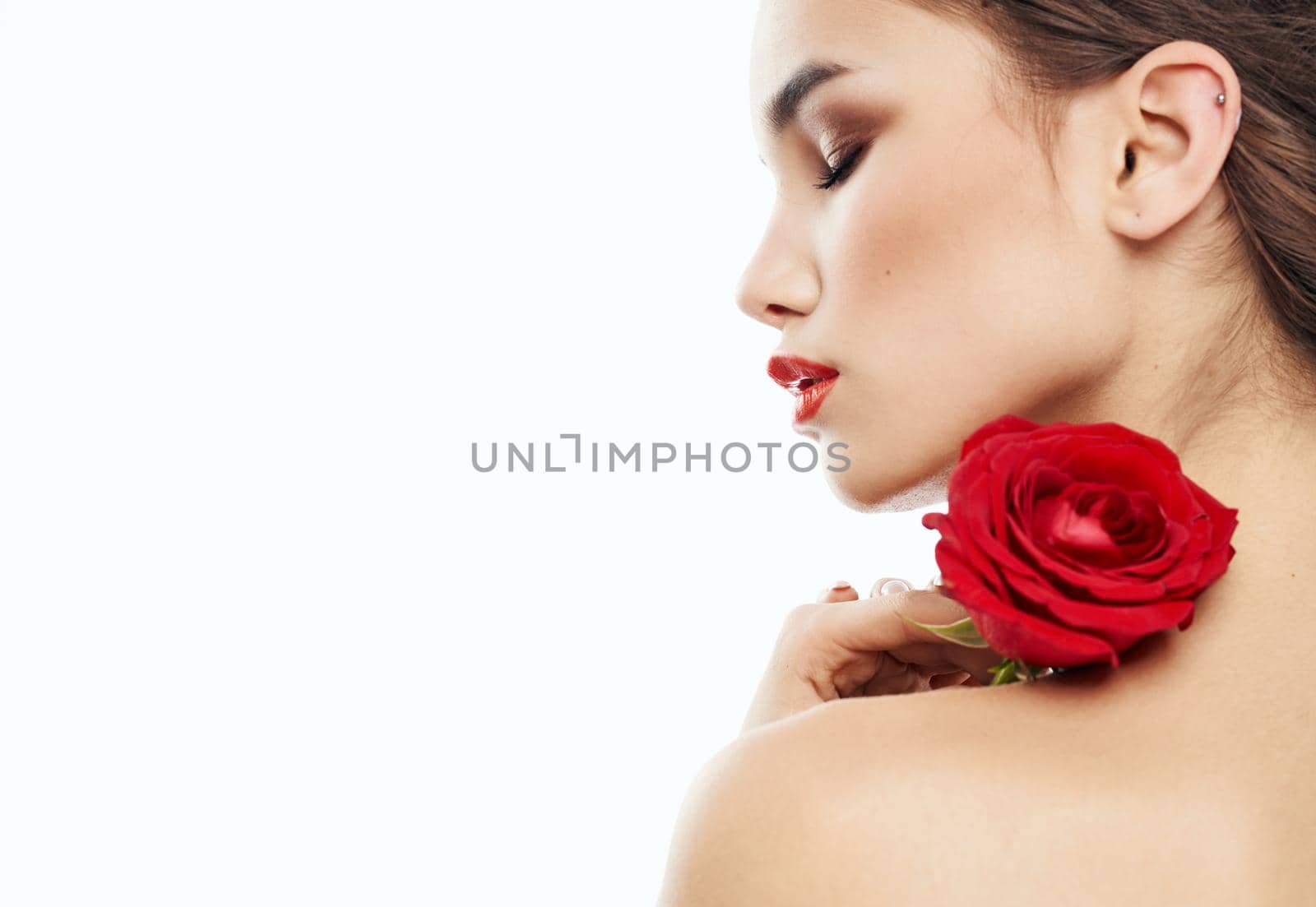 sexy woman with red flower on shoulder on light background cropped back view. High quality photo