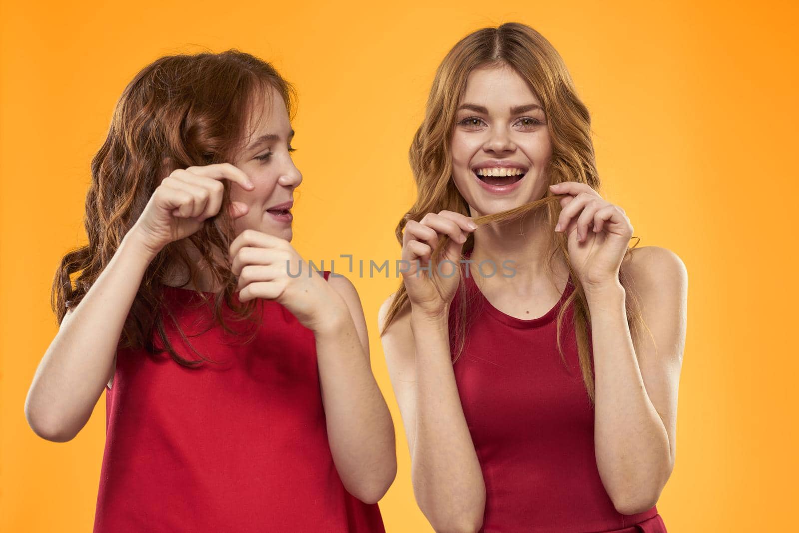 Mom and daughter in red dresses entertainment lifestyle yellow background. High quality photo