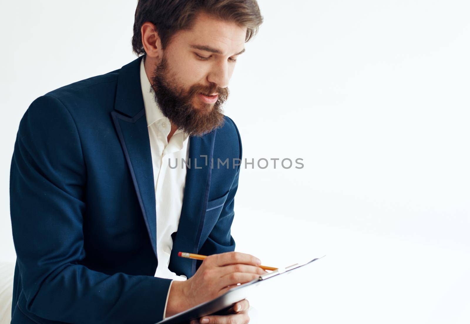 A man in a jacket and shirt with documents on his knees. High quality photo