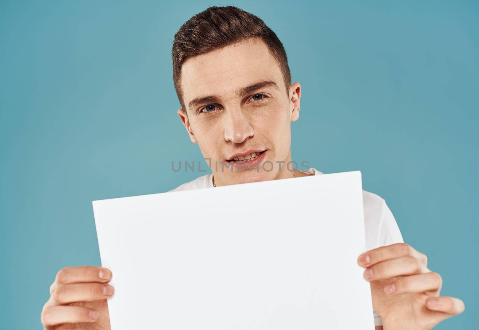 guy with flyer in hand Poster mockup blue background cropped view. High quality photo