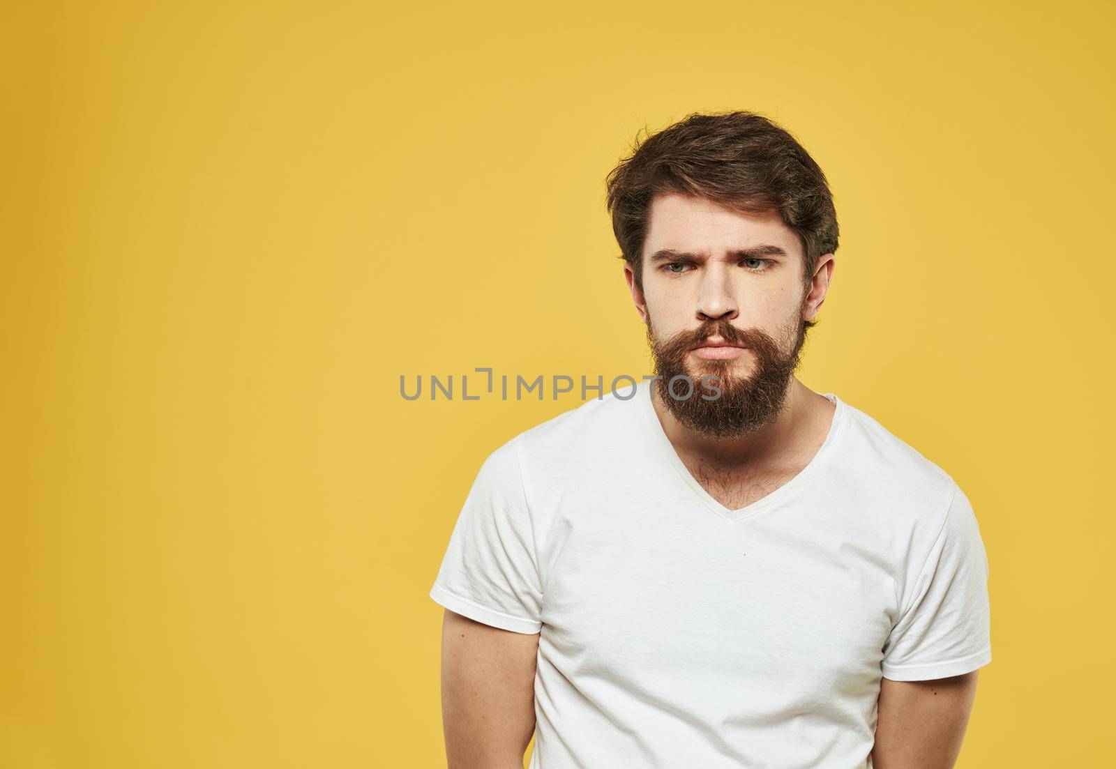 Portrait of handsome man yellow background beard brunette model. High quality photo