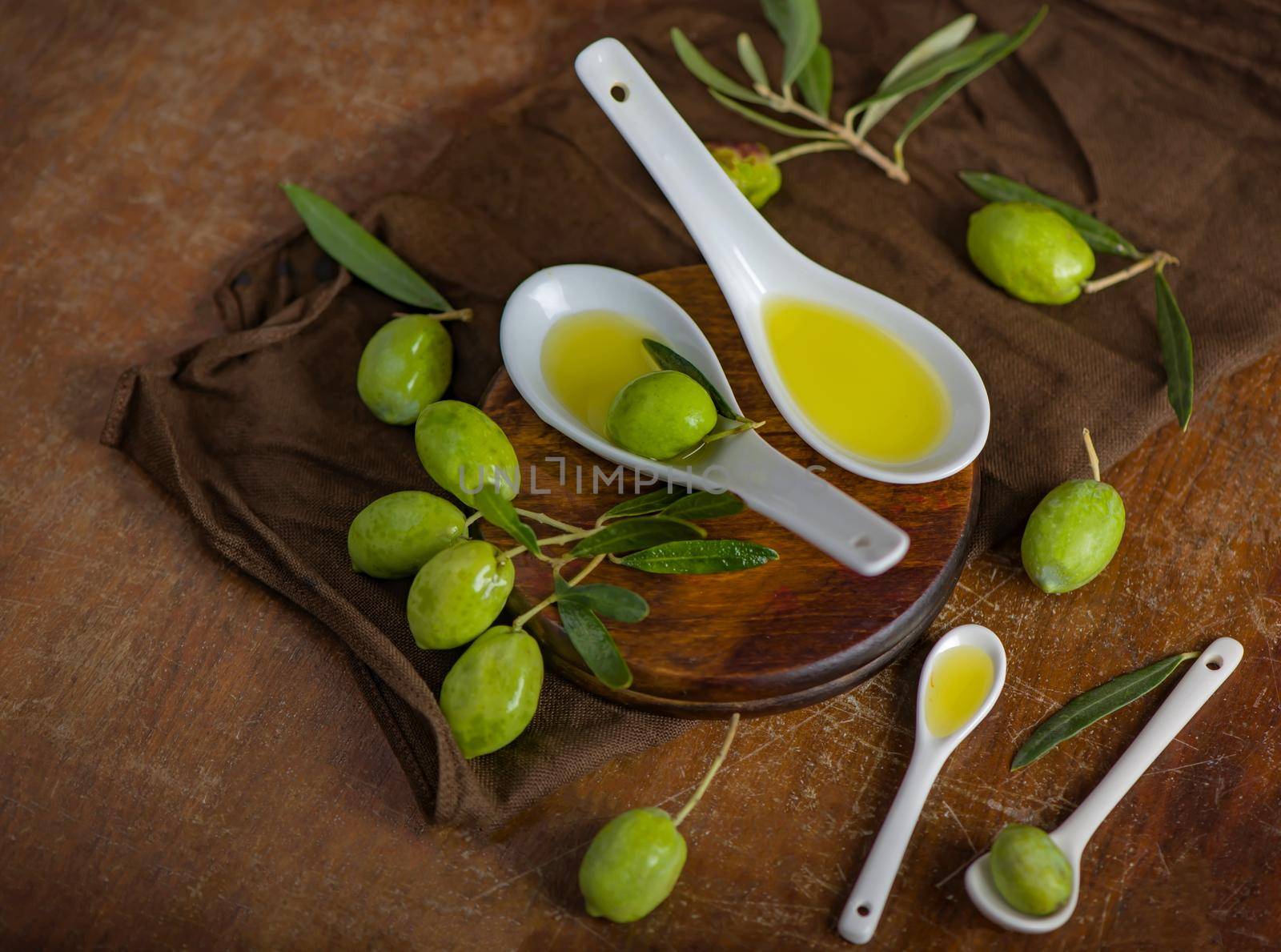 Olive oil and olive branch on black background.